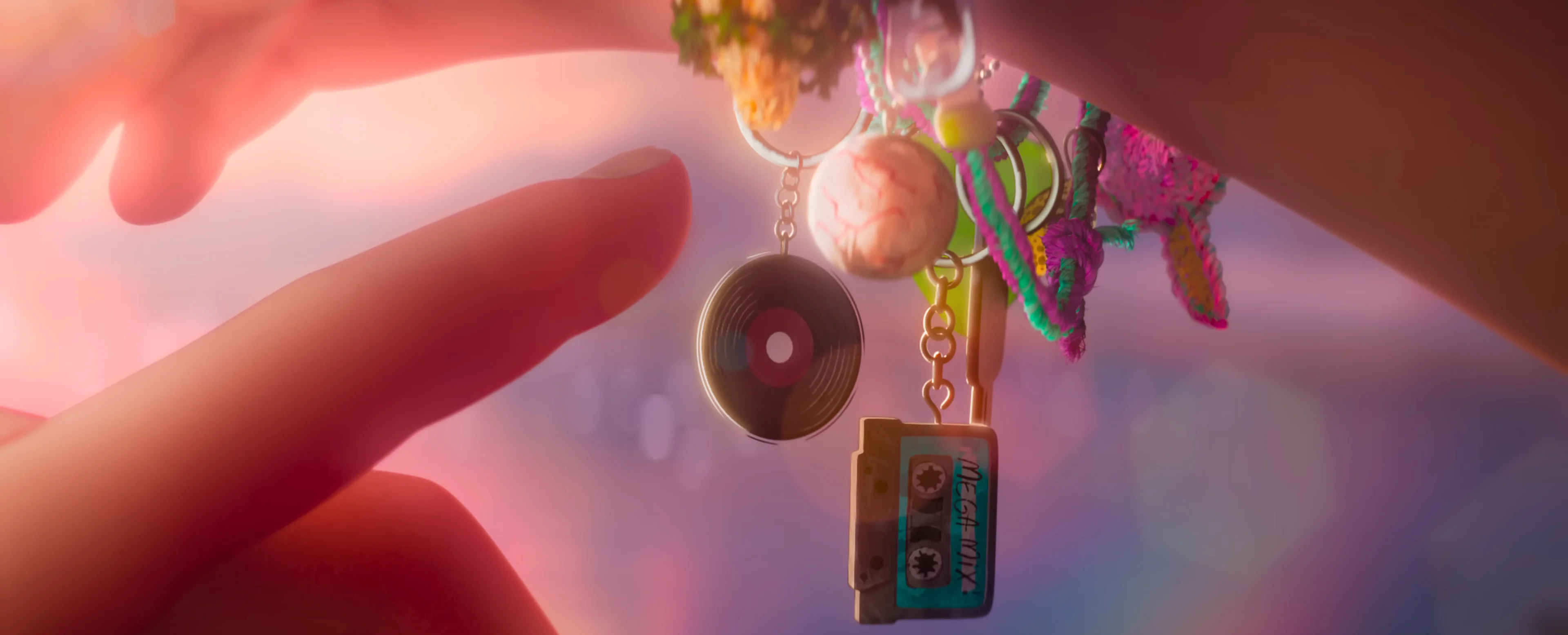 A hand reaches toward a friendship bracelet with record and cassette charms.