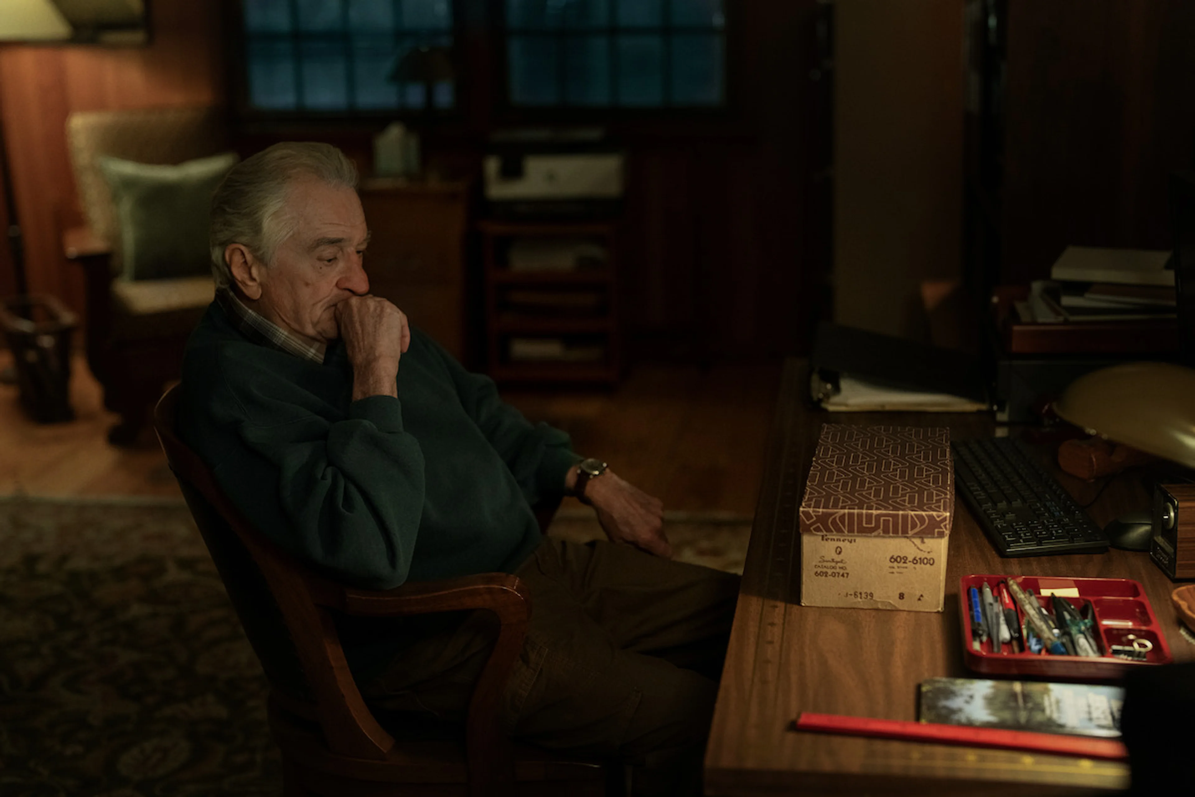 Robert De Niro as Pete Willis sits at a desk in The Whisper Man.