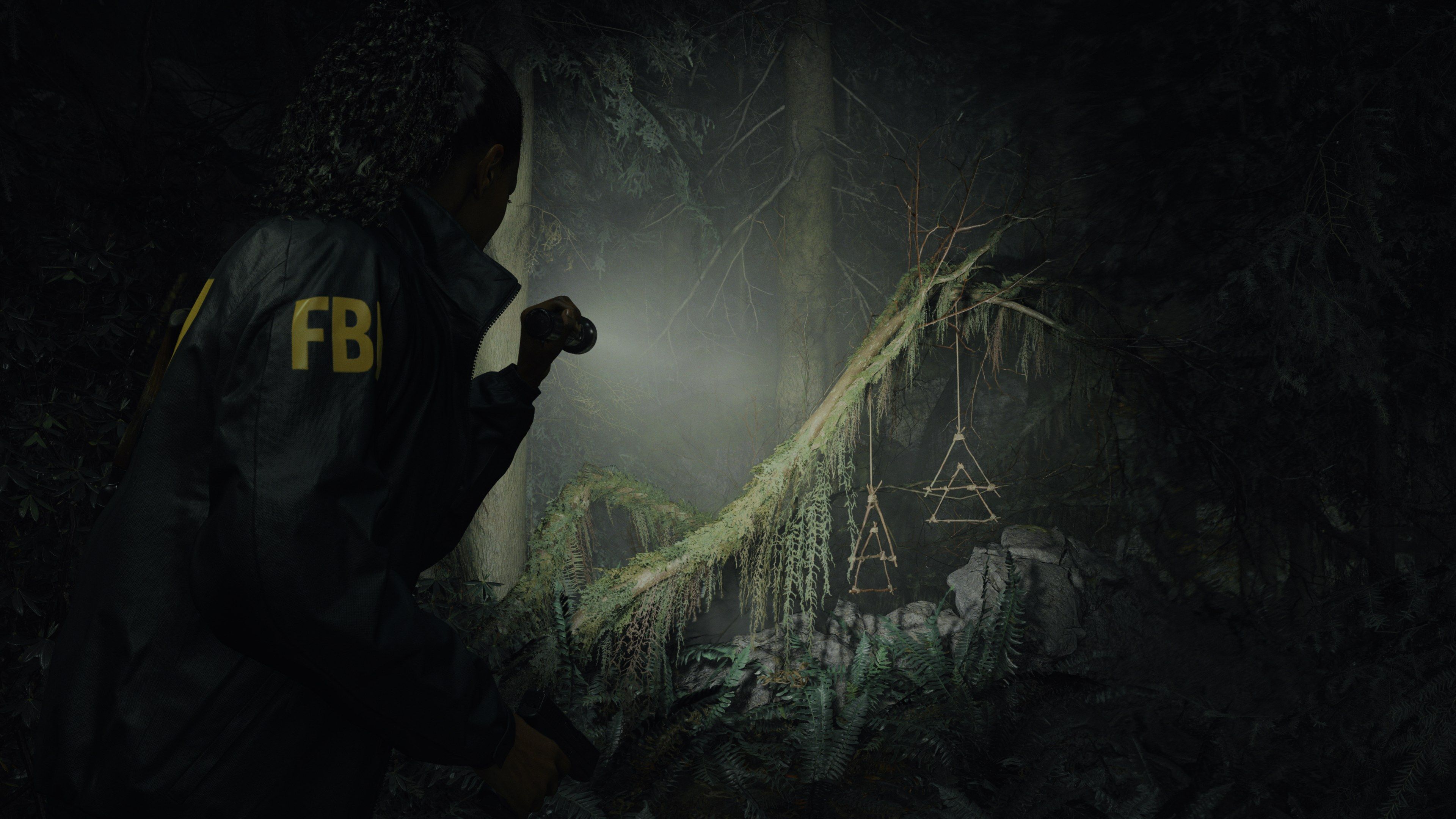 Saga explores a dark forest with a flashlight.