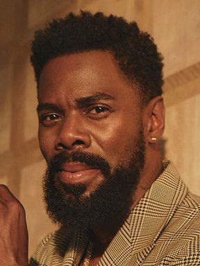 Portrait of Colman Domingo with a beard and checked jacket in warm light.