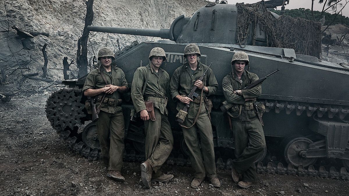 Nicholas Galitzine, Bill Skarsgård, Ray Nicholson and Tom Francis stand in Marine uniforms beside a tank in The Mosquito Bowl.