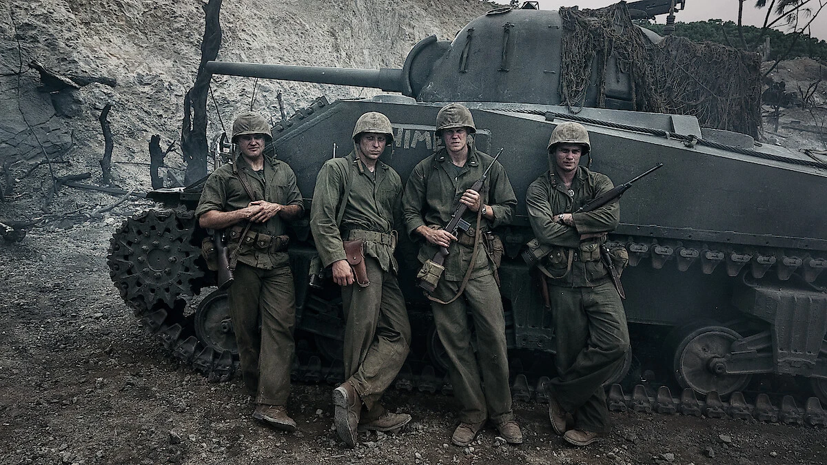 Nicholas Galitzine, Bill Skarsgård, Ray Nicholson and Tom Francis stand in Marine uniforms beside a tank in The Mosquito Bowl.