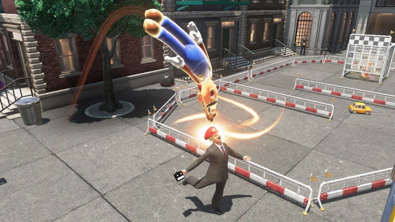 Mario uses Cappy near a tall object in a city street.