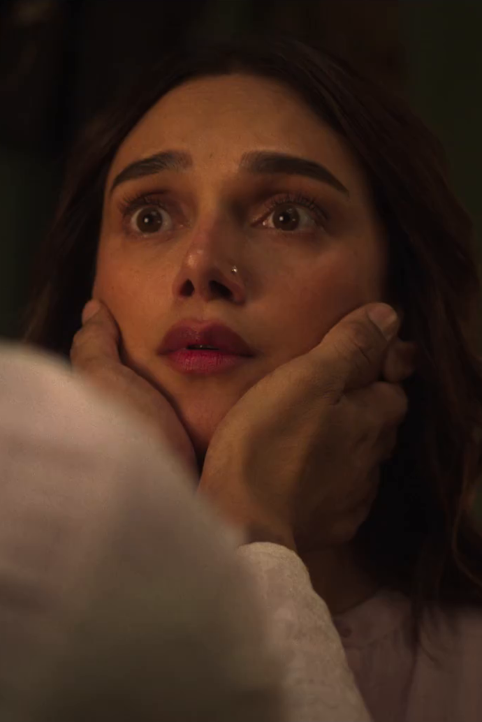 A woman looks upward while another character holds her face in a close-up from the official Lust Stories 3 trailer.