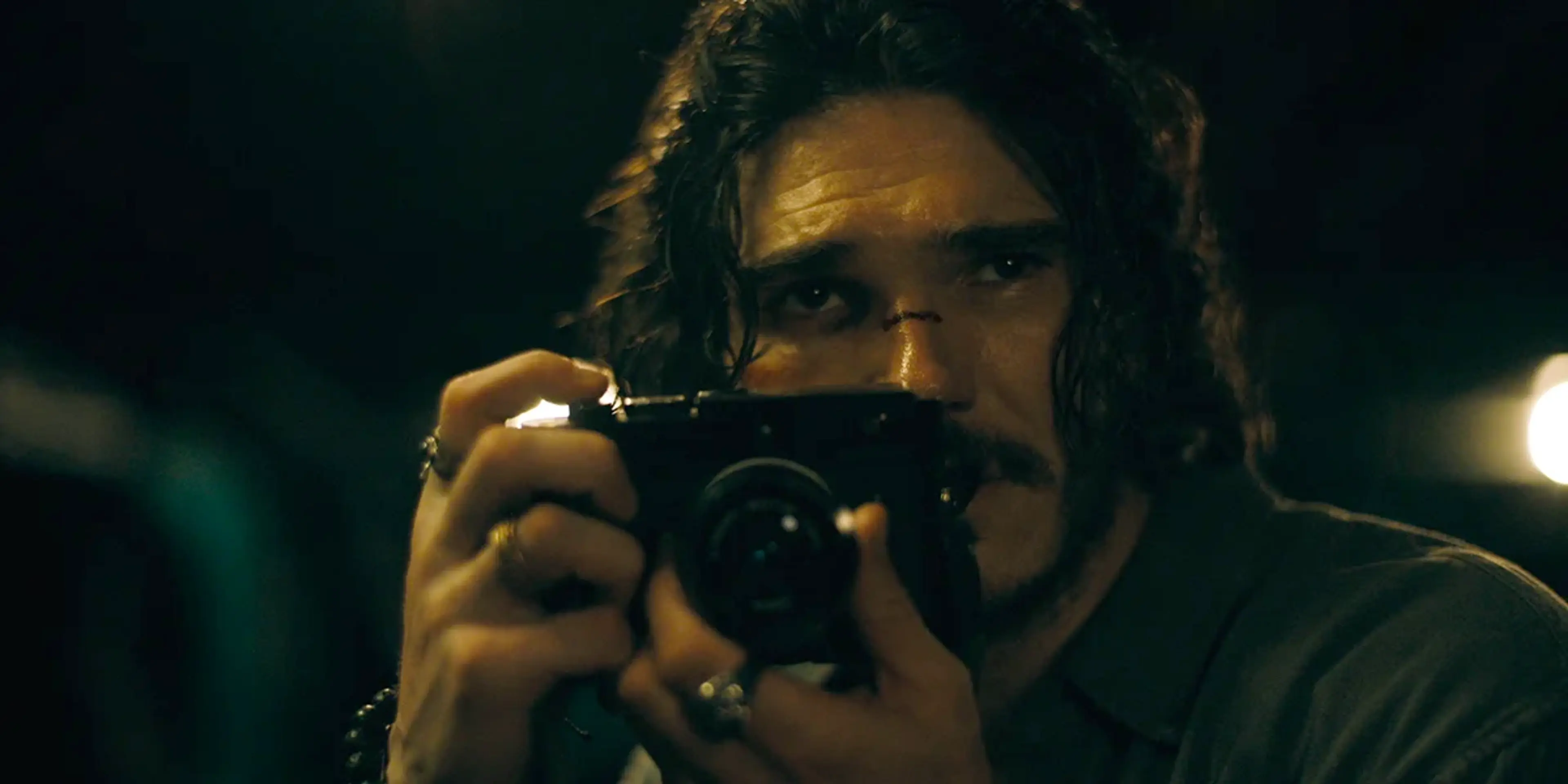 Fra Fee as Joe Wallace holds a camera close to his face in The Last Photograph.