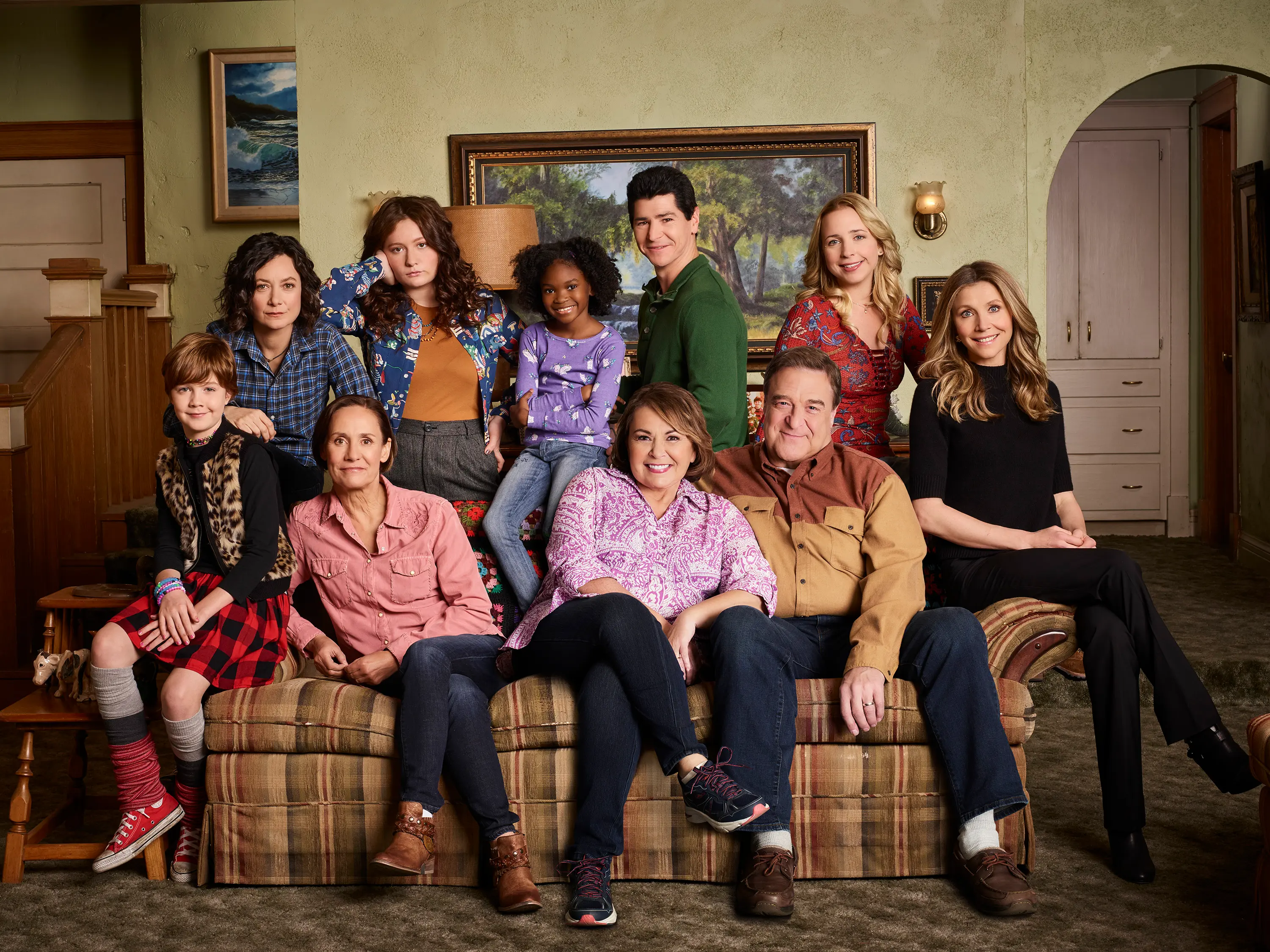 The 2018 Roseanne cast, including Michael Fishman standing behind Roseanne Barr on the couch.