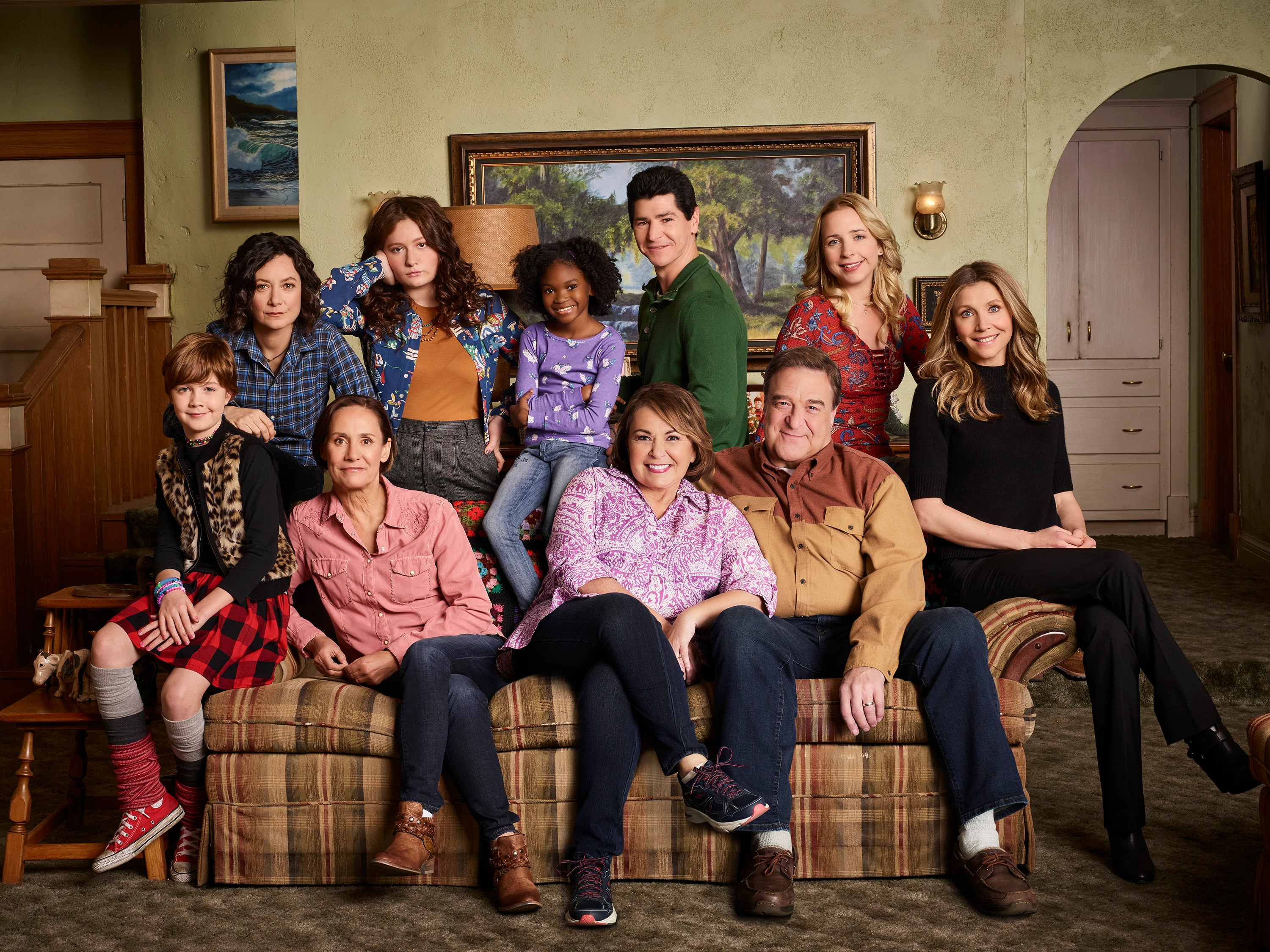 The 2018 Roseanne cast, including Michael Fishman standing behind Roseanne Barr on the couch.