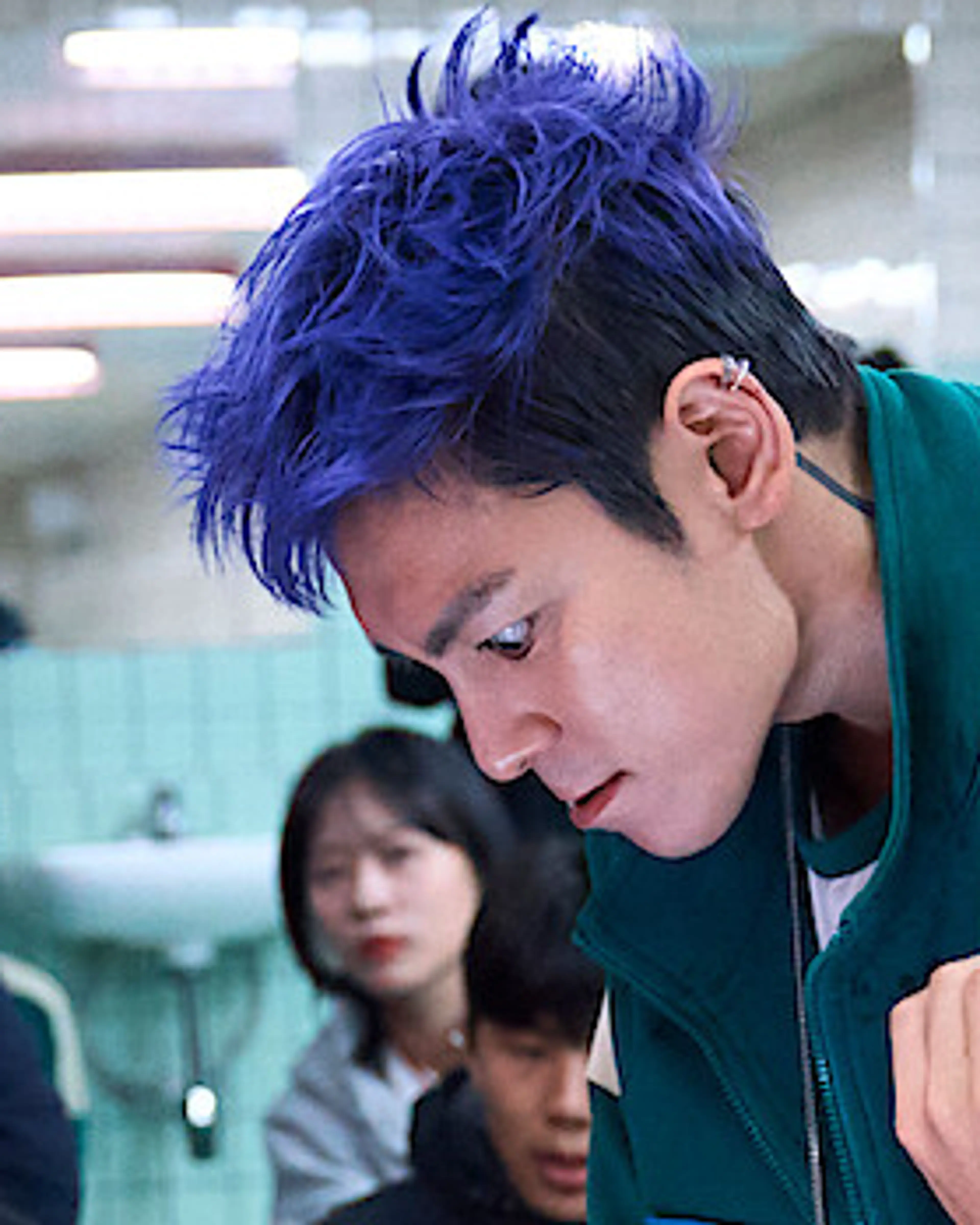 Choi Seung-hyun, known as T.O.P, with purple hair on the Squid Game Season 2 set.