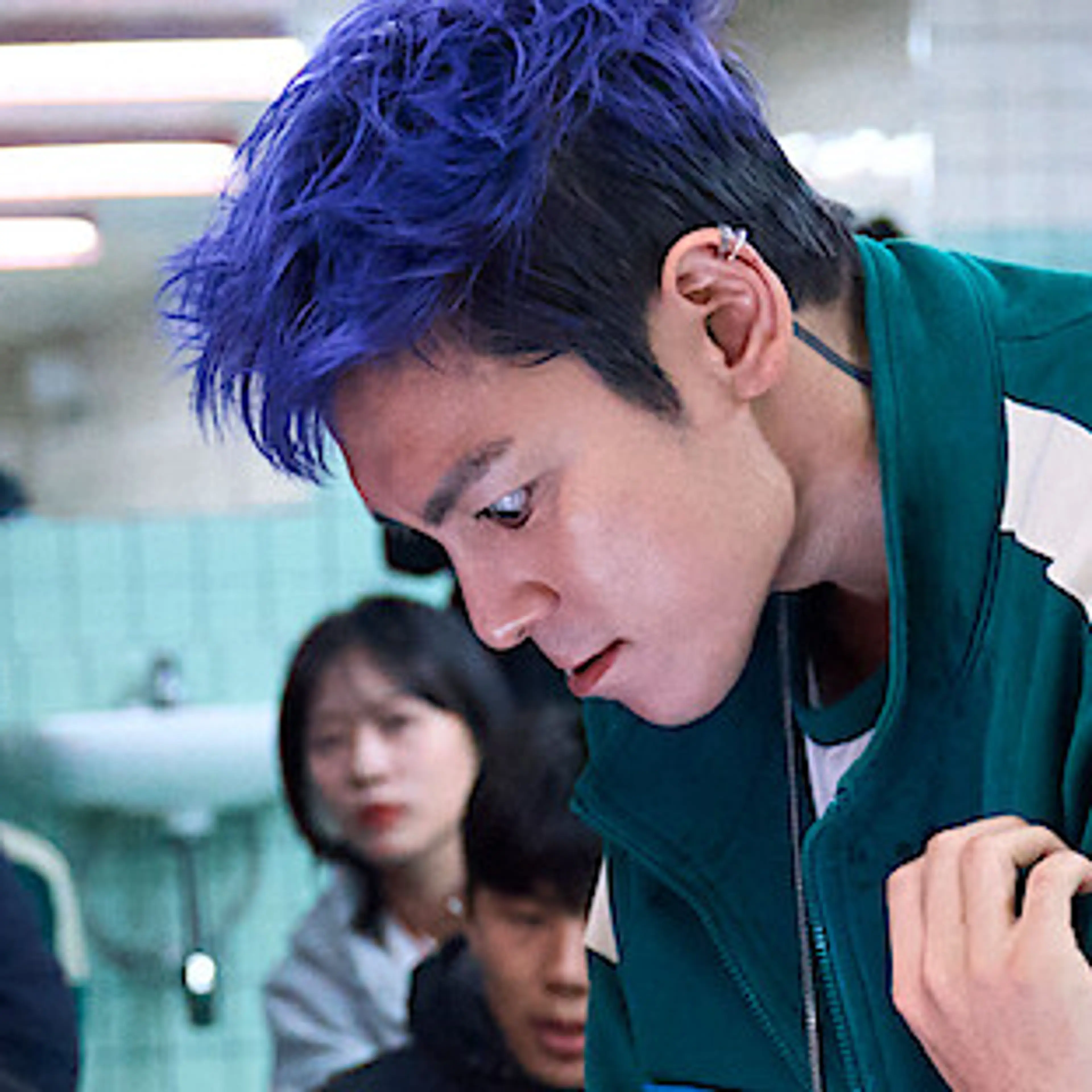 Choi Seung-hyun, known as T.O.P, with purple hair on the Squid Game Season 2 set.