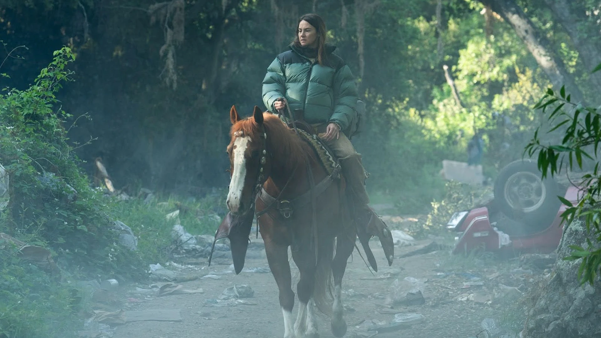 Shailene Woodley rides a horse through a wooded road as Annie in Paradise Season 2.