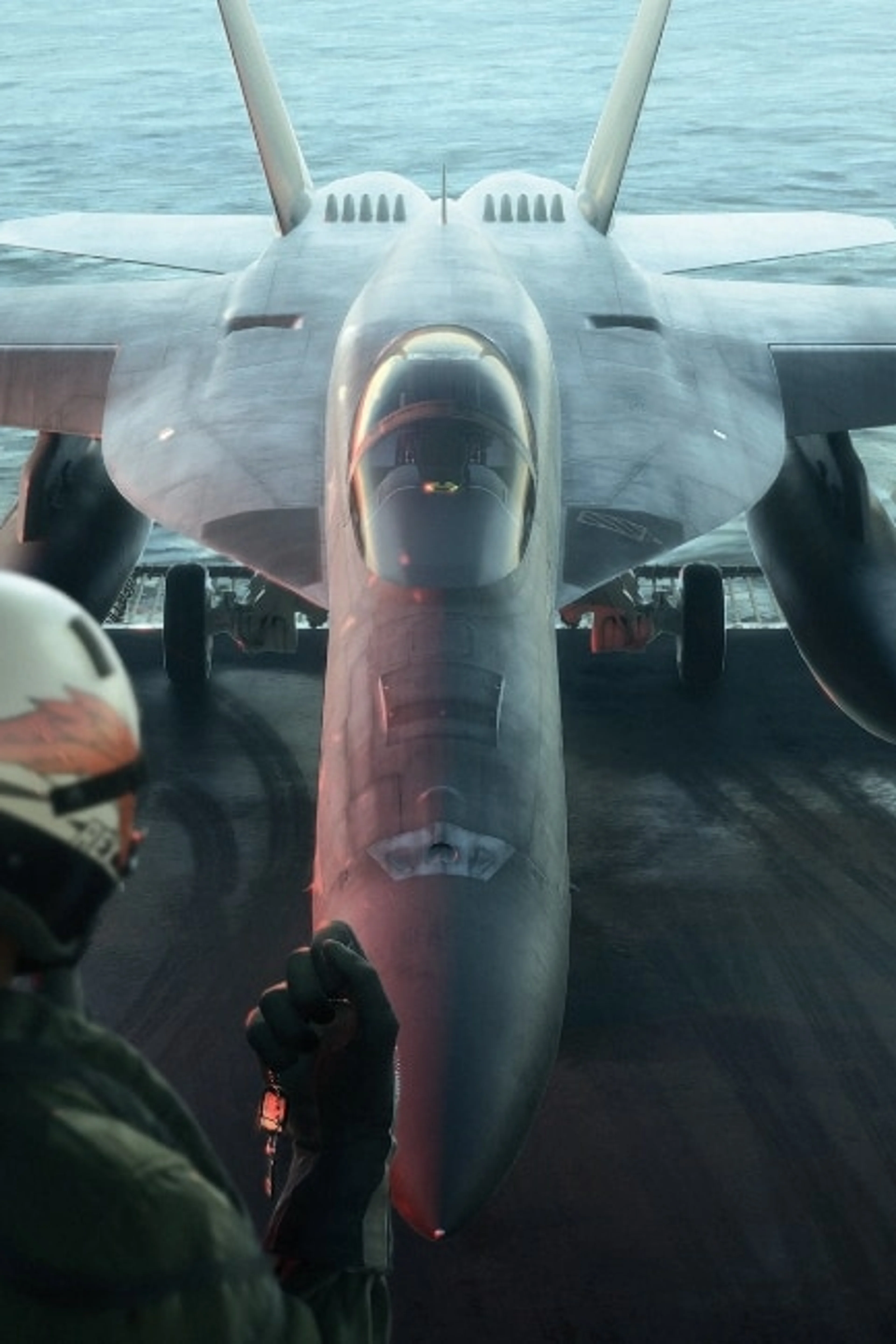A pilot stands on an aircraft carrier facing a fighter jet at sea in Ace Combat 8.