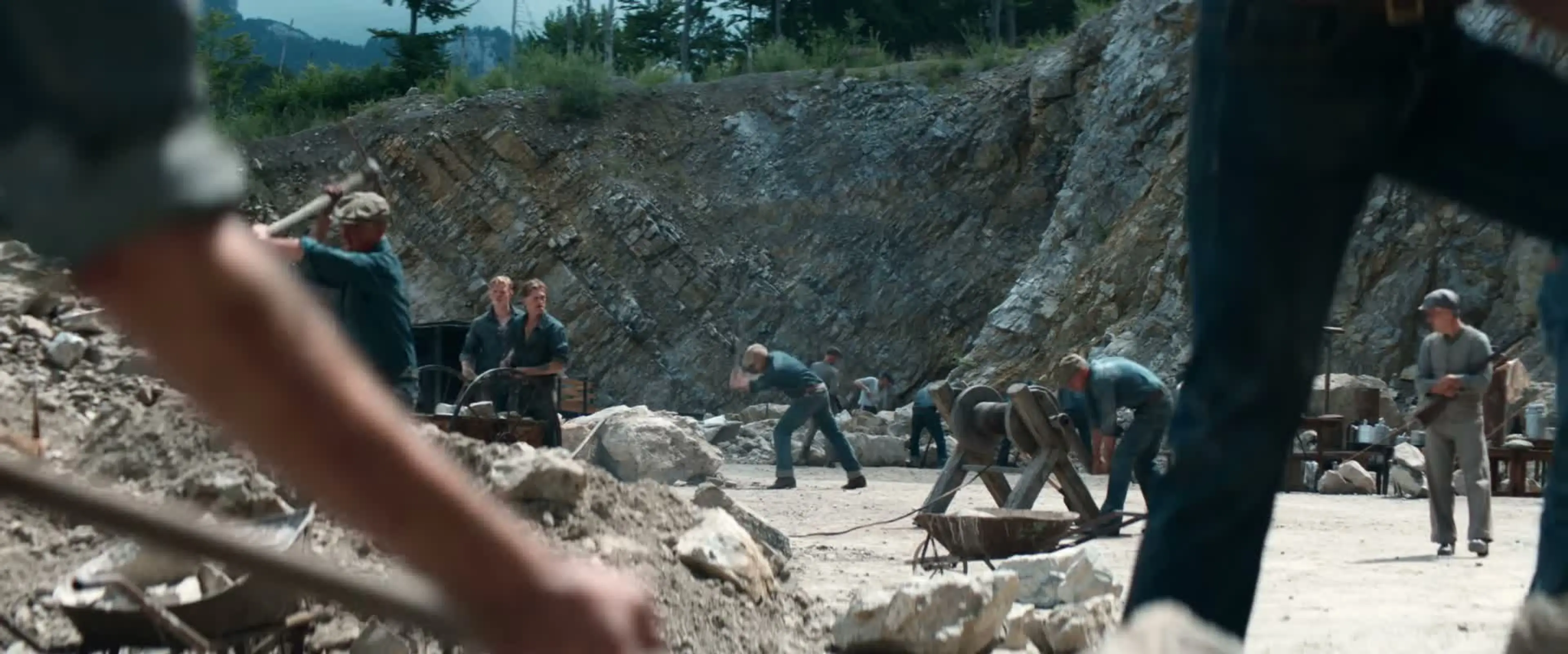 Prisoners break rocks under supervision at the work camp.