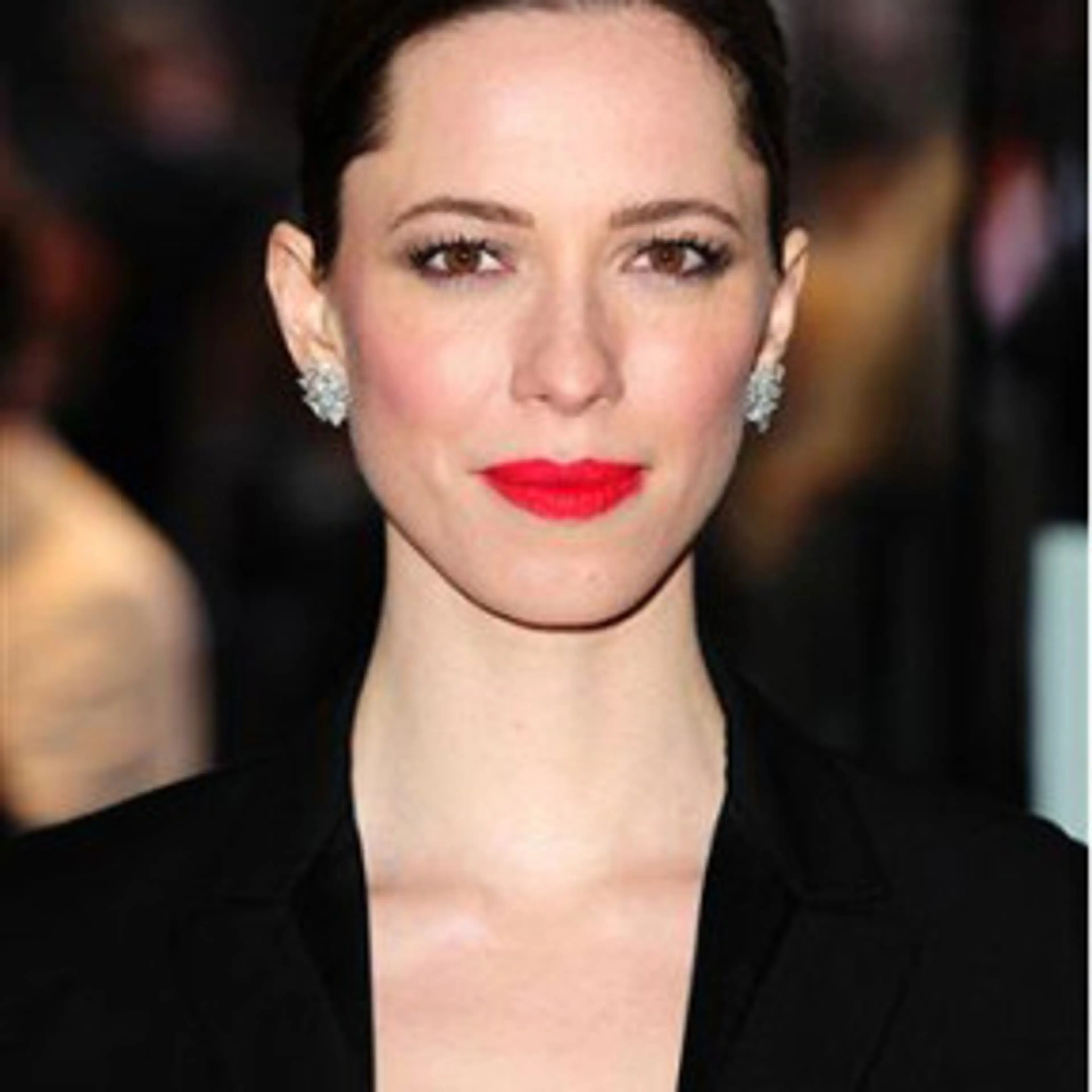 Portrait of Rebecca Hall with dark hair and a black jacket.