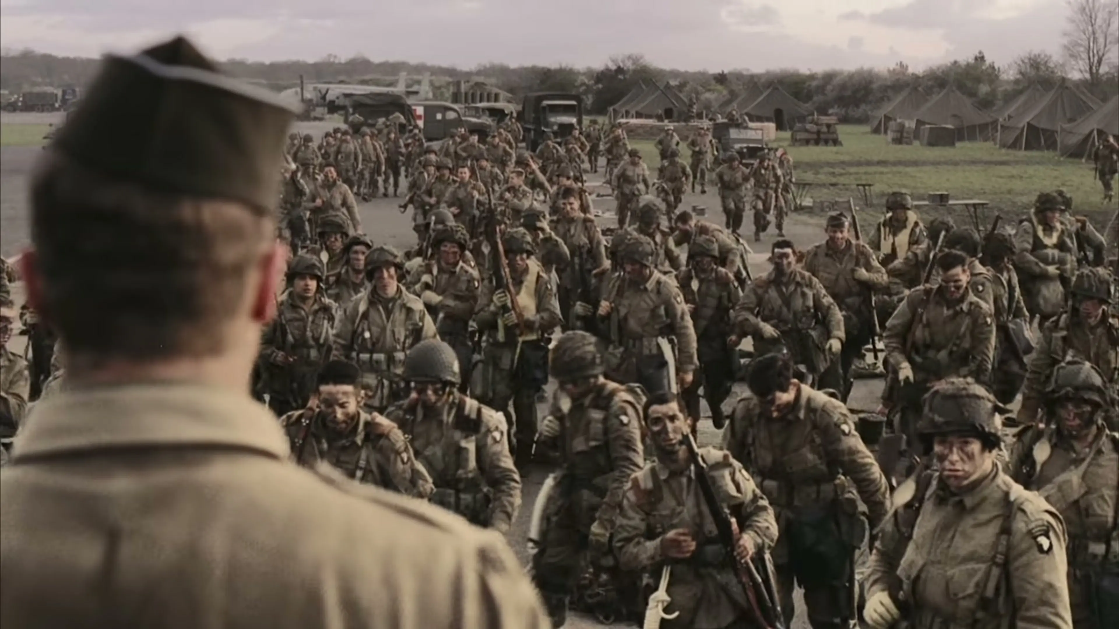 Soldiers of Easy Company gather in formation at a military camp in Band of Brothers: Legacy.