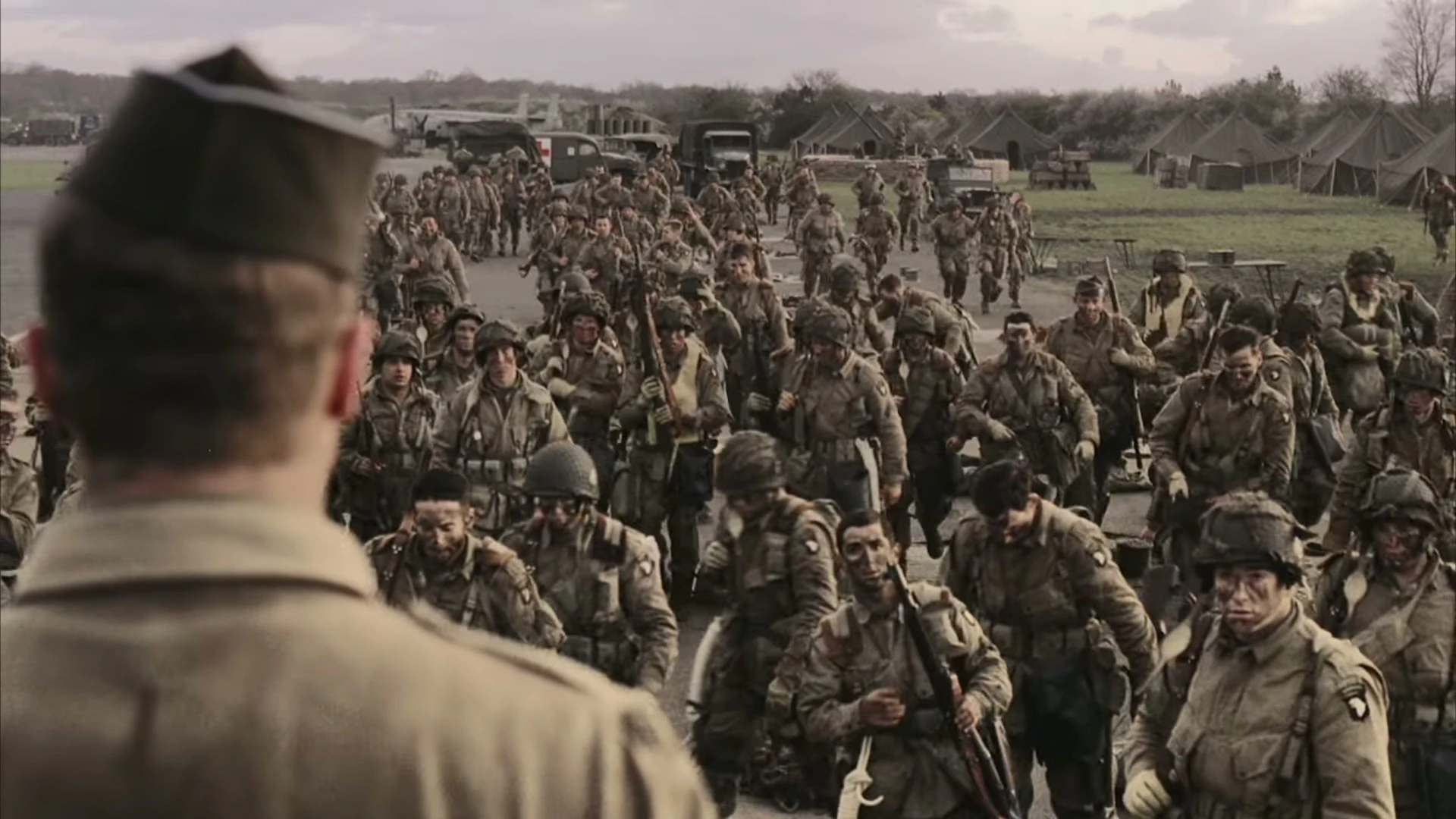 Soldiers of Easy Company gather in formation at a military camp in Band of Brothers: Legacy.