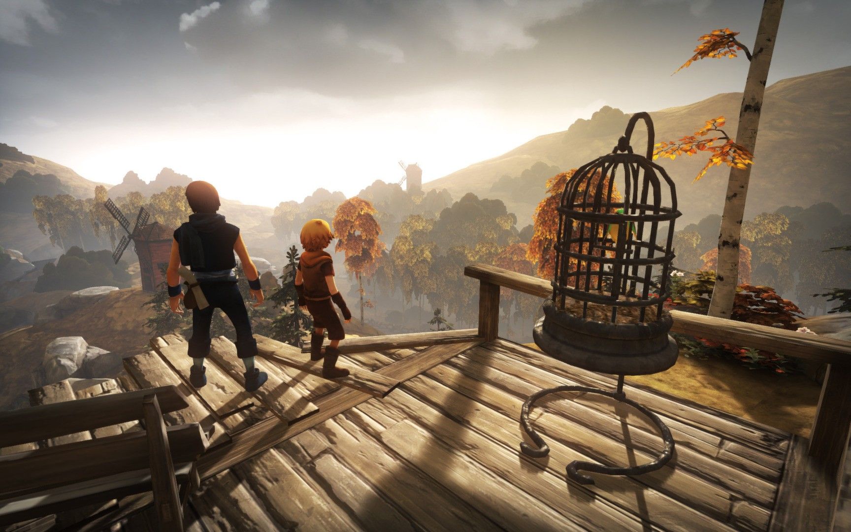 Both brothers stand on a wooden platform near a suspended cage.