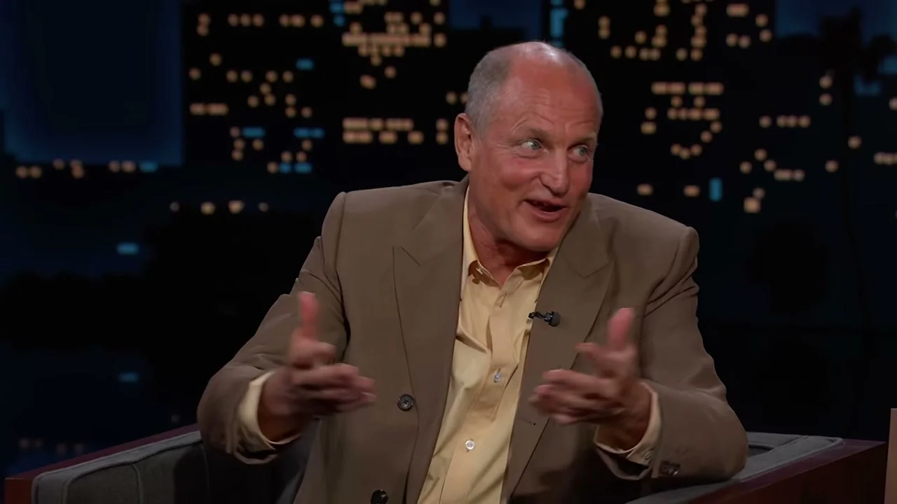 Woody Harrelson gestures with one hand while answering Jimmy Kimmel.