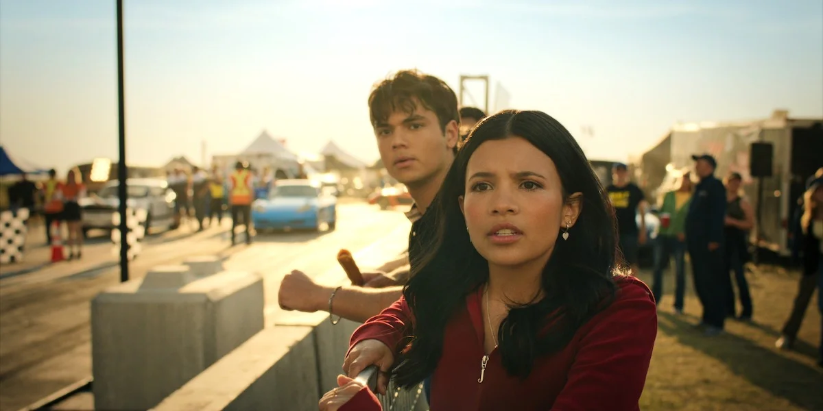 Jackie stands with another character near a racetrack in My Life With the Walter Boys Season 3.