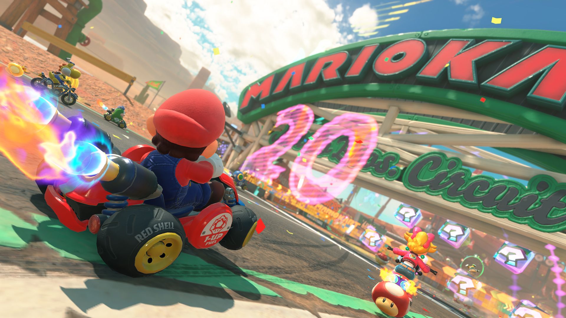 Mario crosses a checkered finish line ahead of other racers in Mario Kart World.