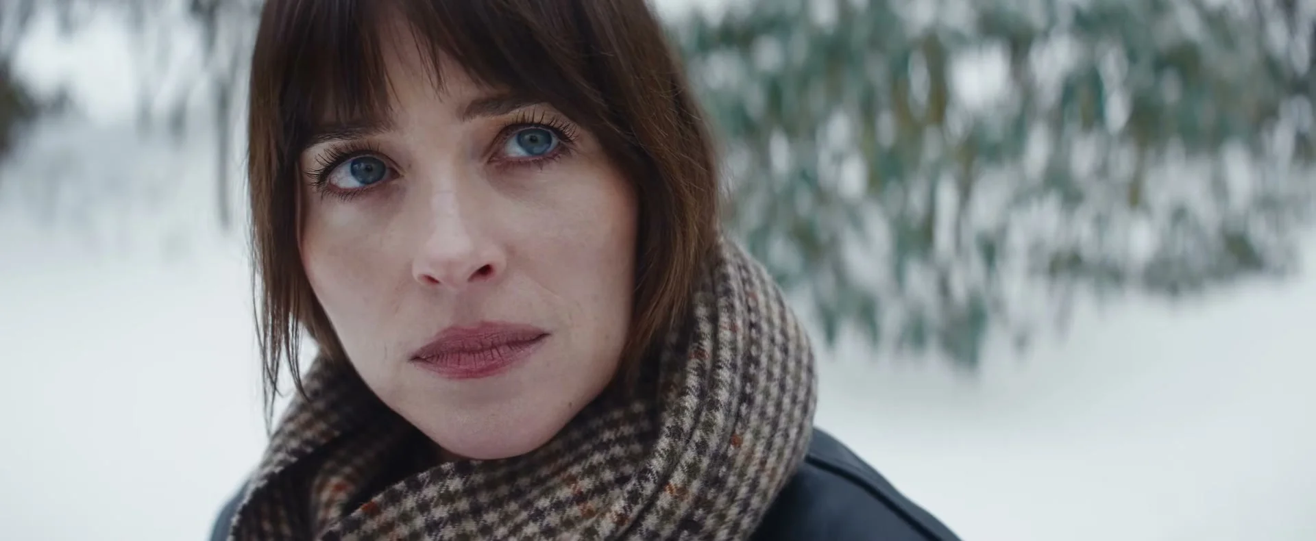 Dakota Johnson as Lowen Ashleigh stands outside in the snow in the official Verity trailer.