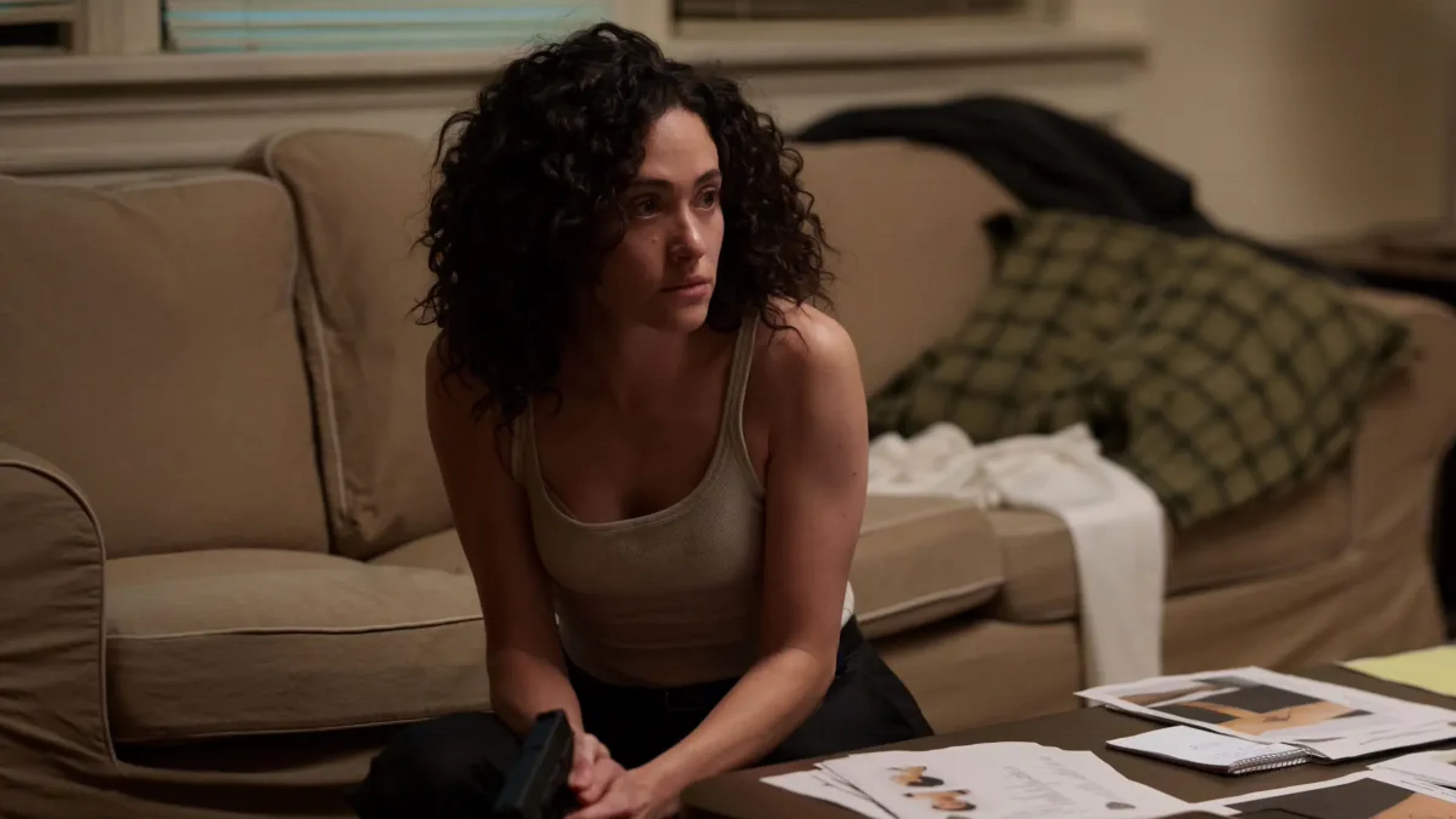 Emmy Rossum as Alice Black sits beside investigation files in an official Furious still.
