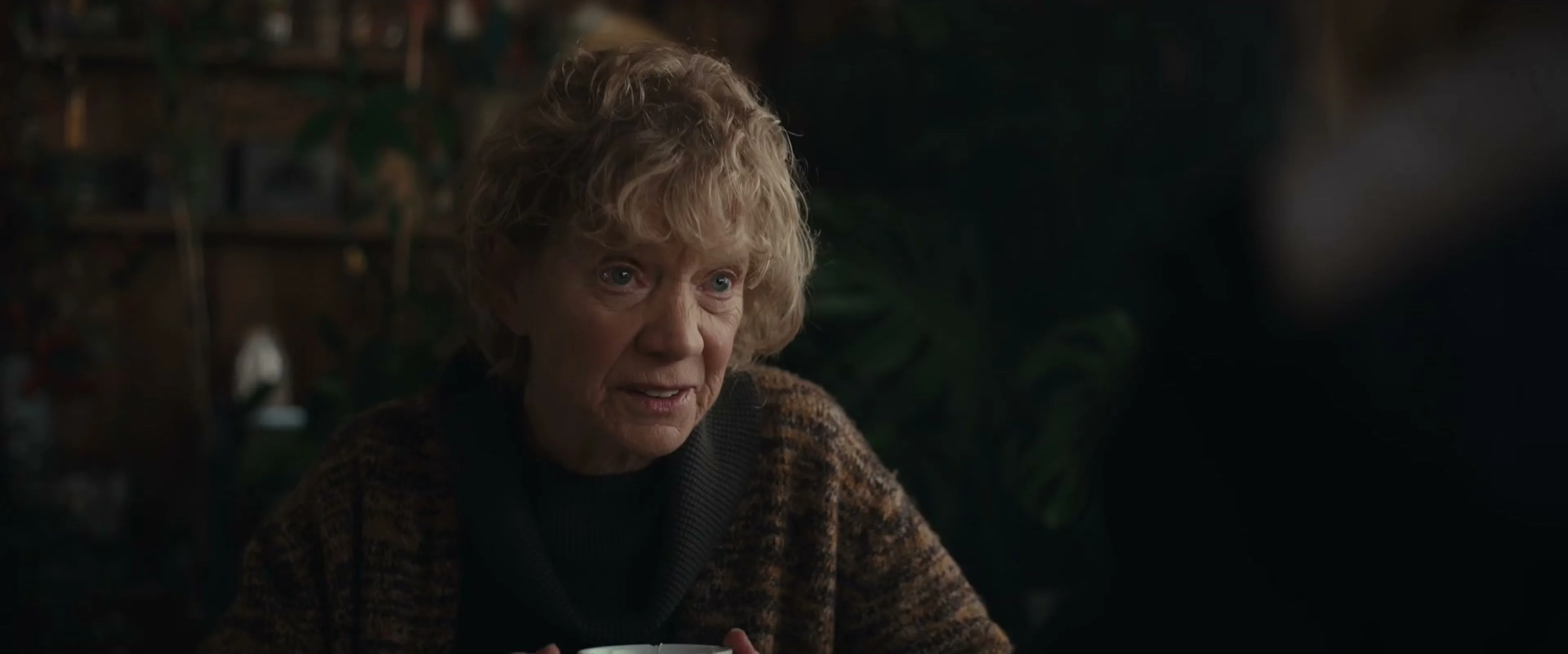 An older woman looks across a room in The Cycle trailer.