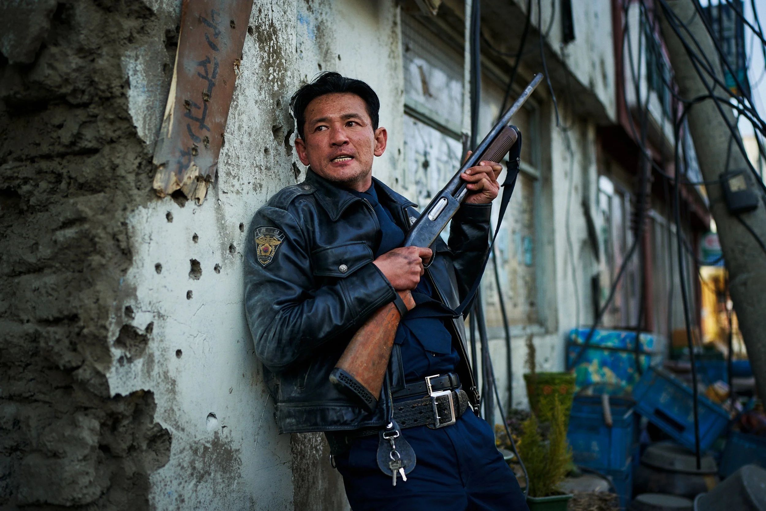 Hwang Jung-min as police chief Bum-seok holds a shotgun in Hope.