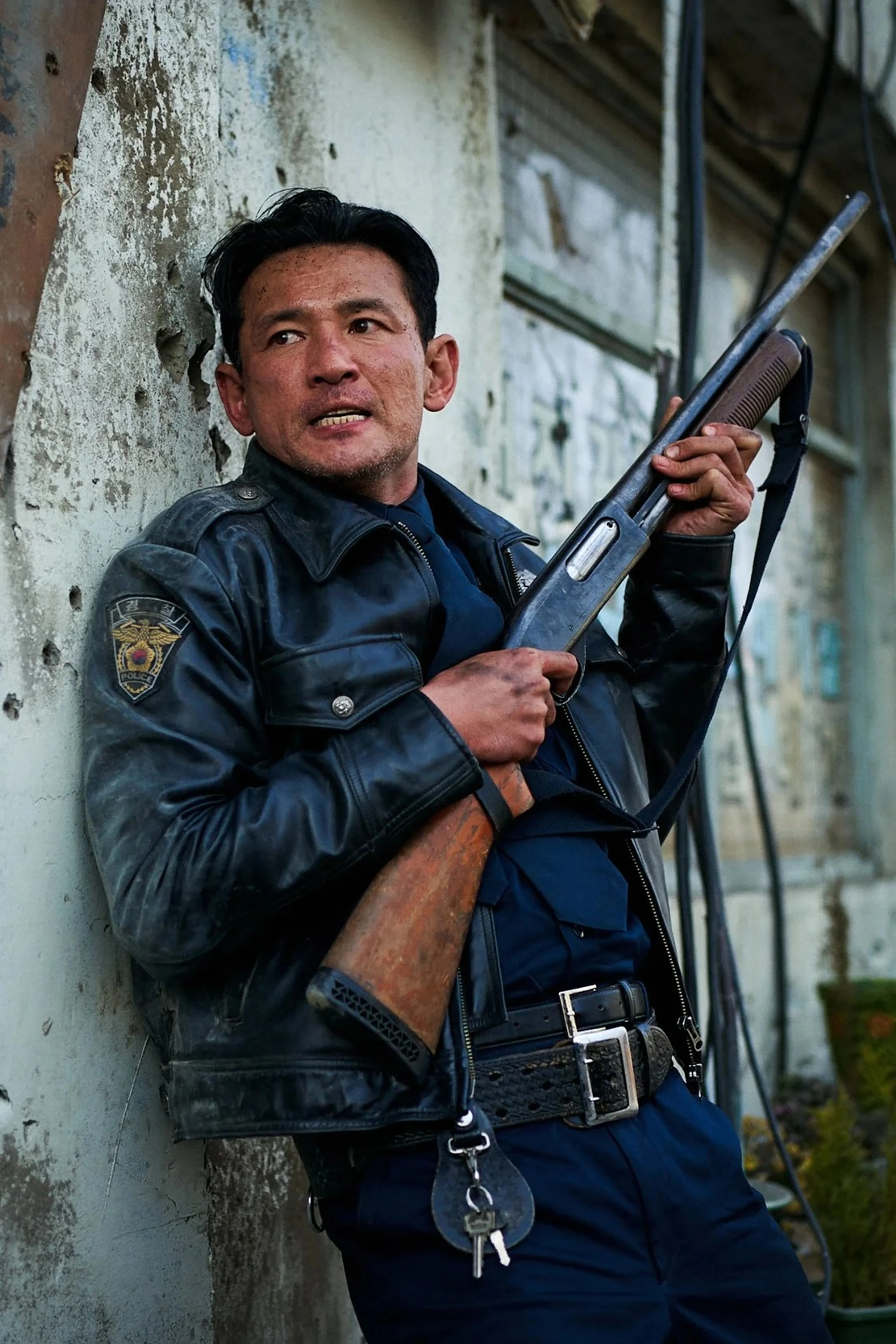 Hwang Jung-min as police chief Bum-seok holds a shotgun in Hope.