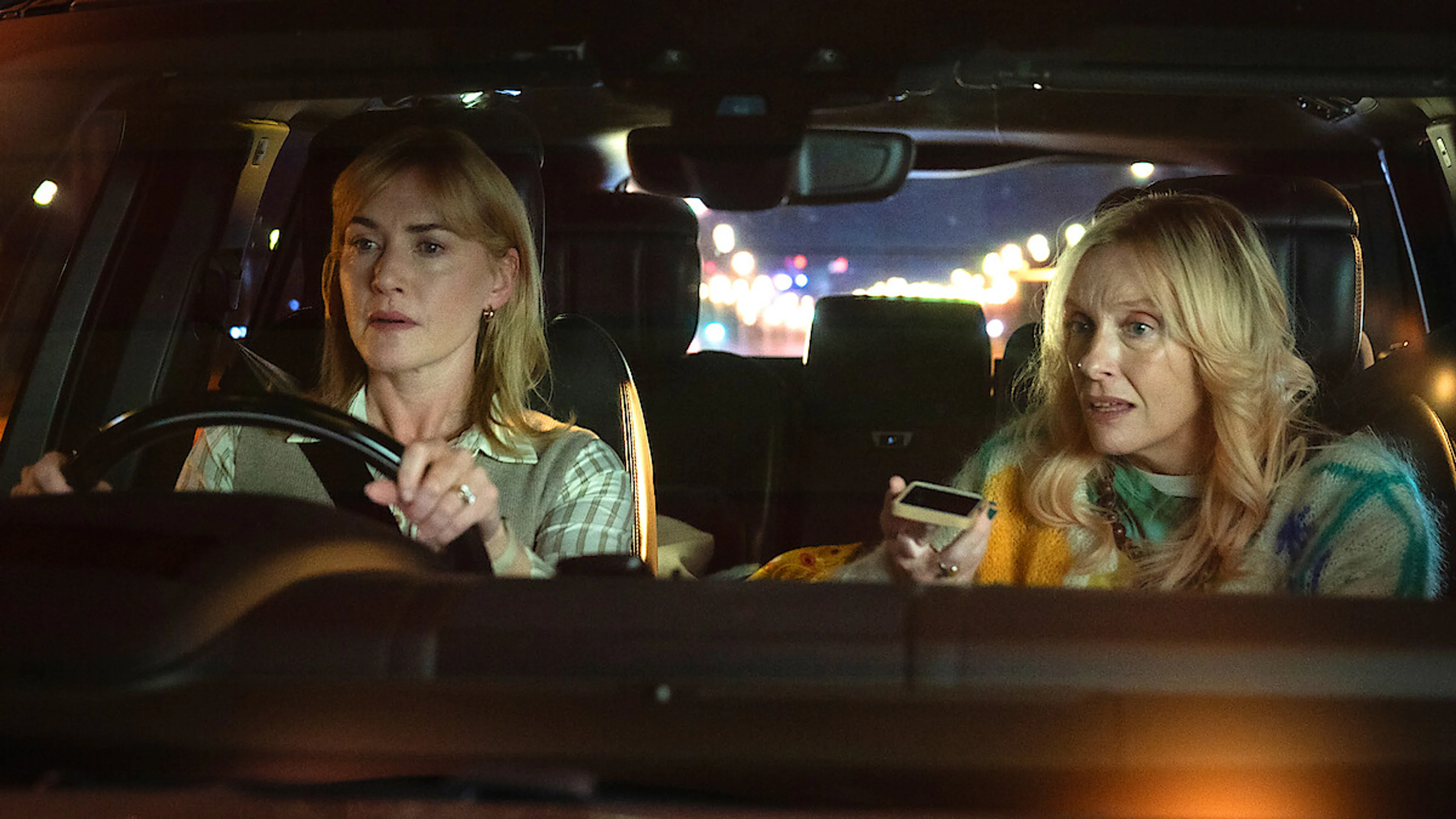 Kate Winslet and Toni Collette sit in a car in an official Goodbye June still from Netflix.