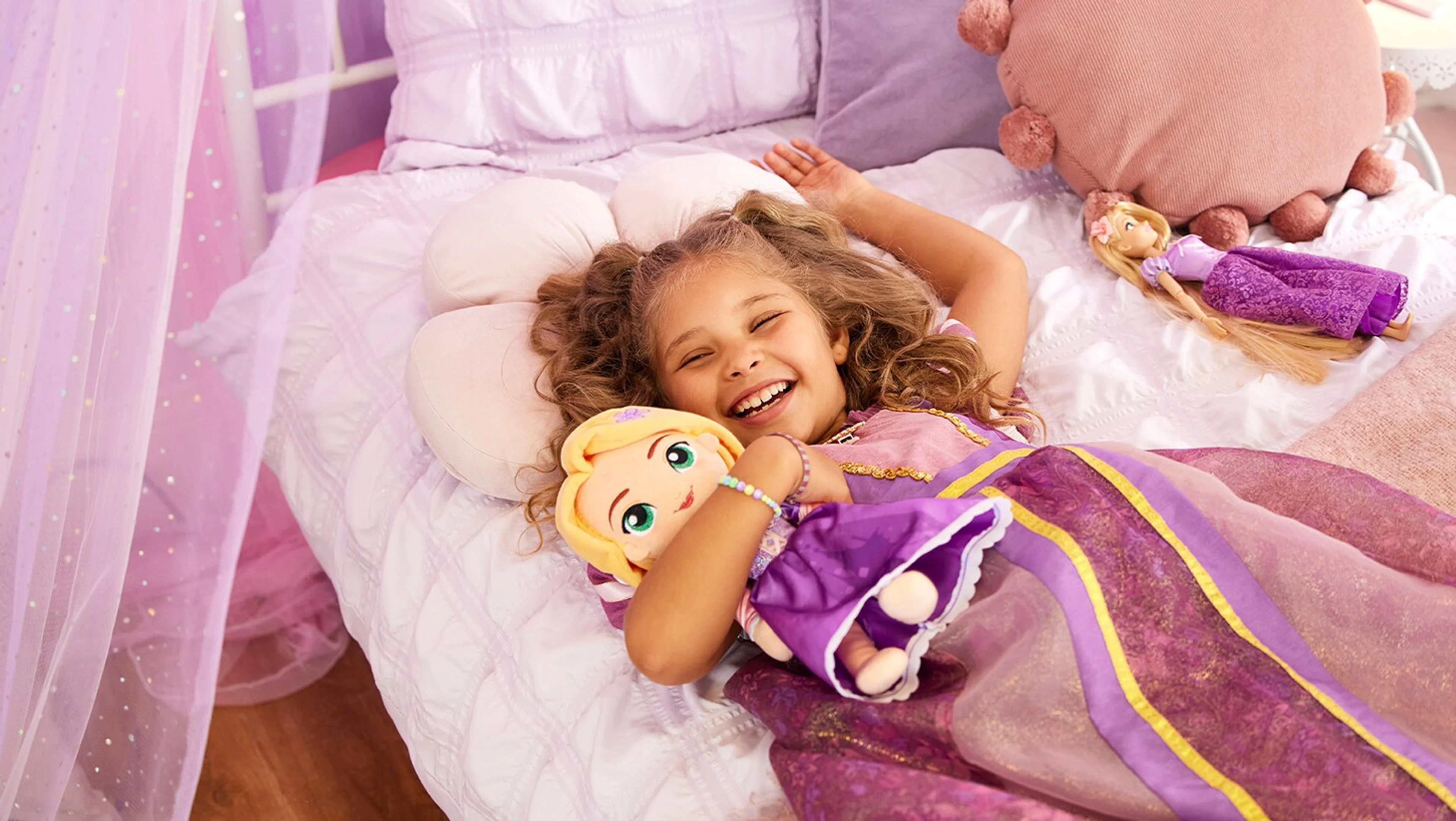 A child dressed as Rapunzel holds Disney Princess toys