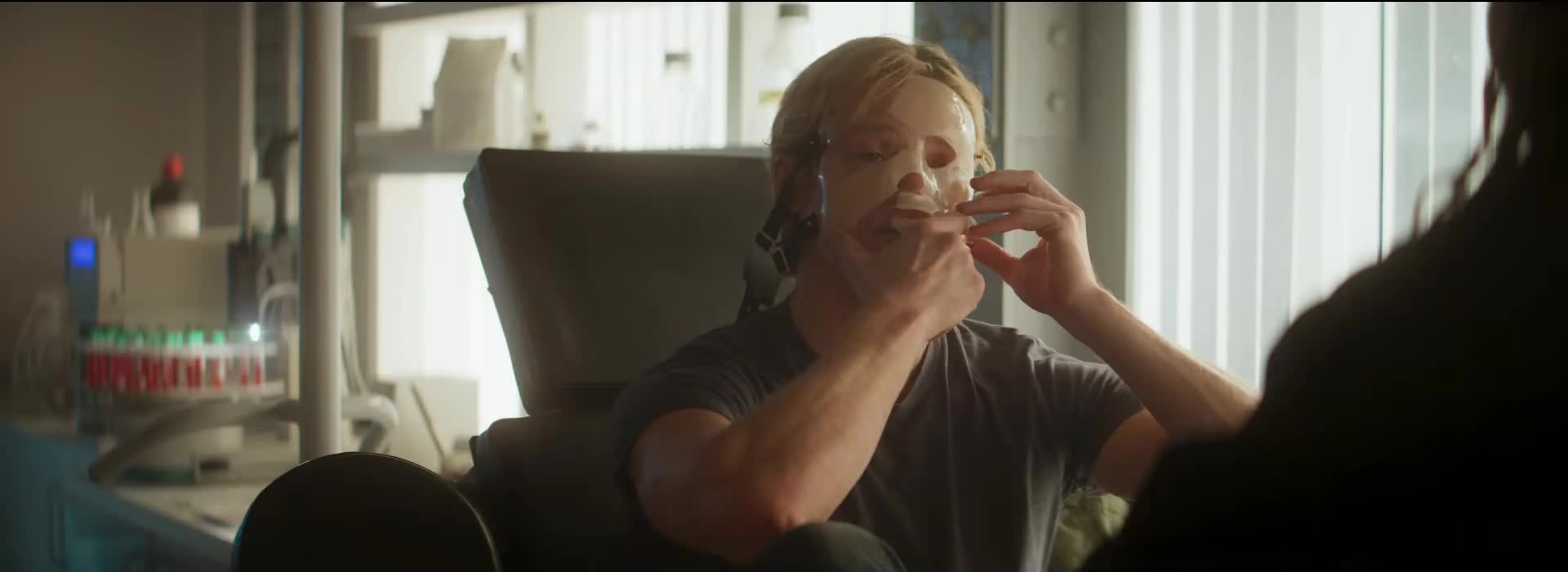 Matt Hagen sits in a clinic and peels a molded treatment away from his face.