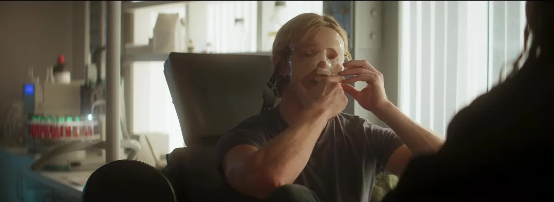 Matt Hagen sits in a clinic and peels a molded treatment away from his face.