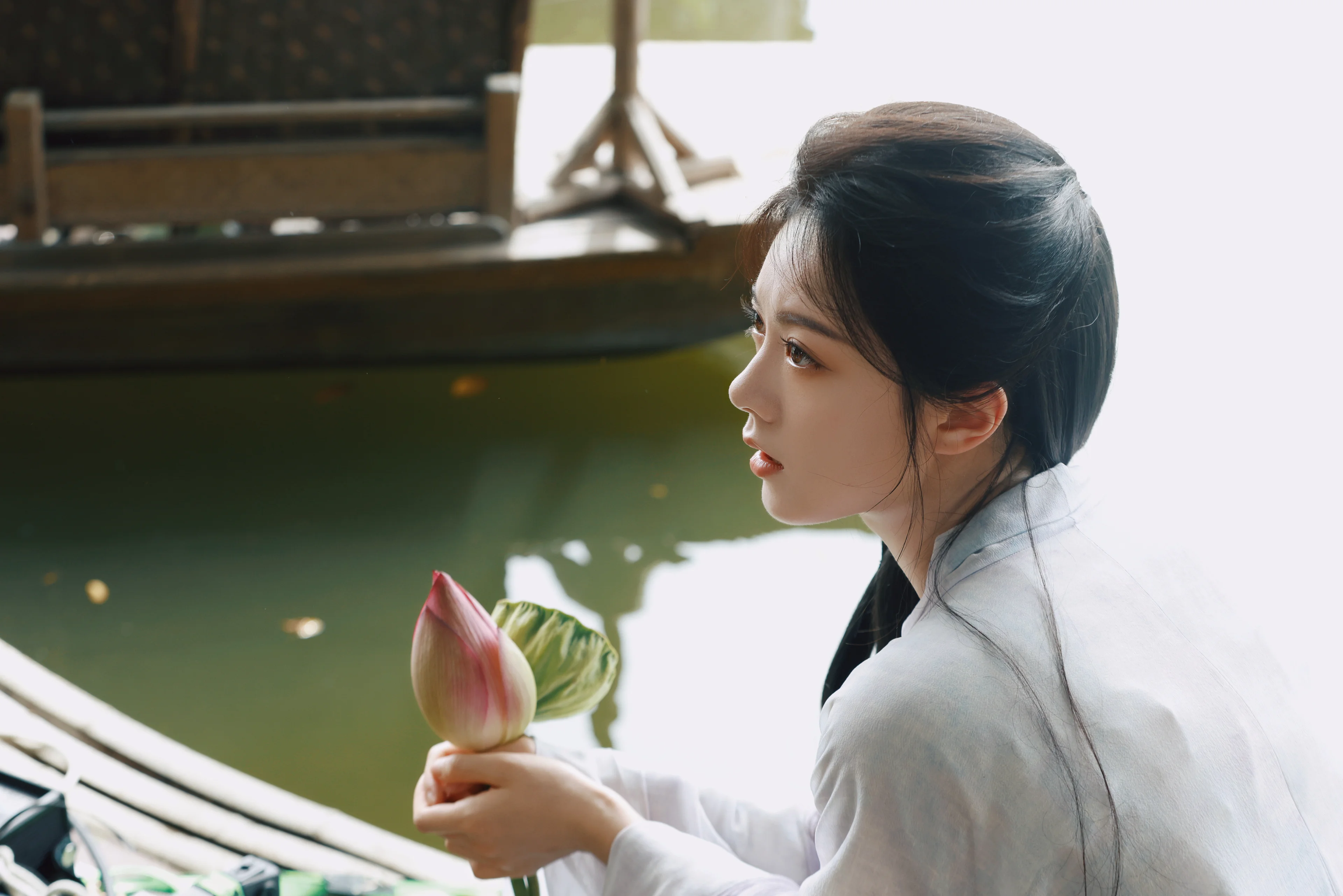 Zhao Jinmai holds a lotus bud in a separate A Journey to Glow promotional portrait.