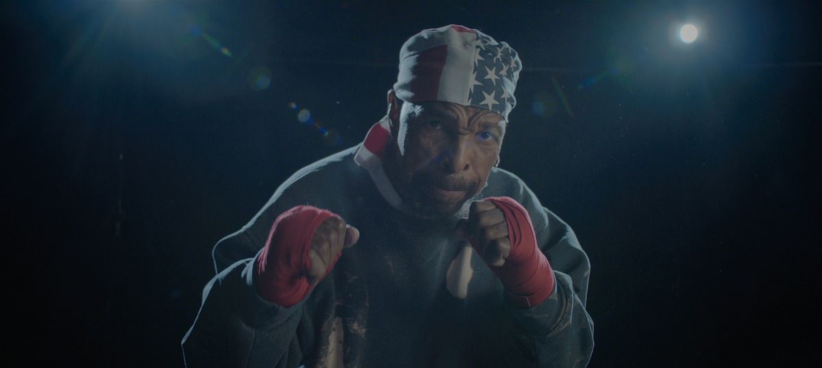 Mr. T raises his fists while wearing an American-flag bandana and red boxing wraps.