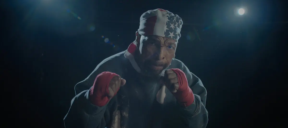 Mr. T raises his fists while wearing an American-flag bandana and red boxing wraps.