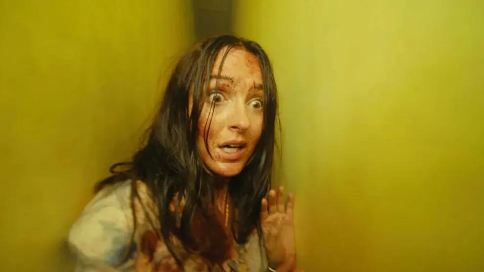 Renate Reinsve’s character stands injured inside a yellow corridor in Backrooms