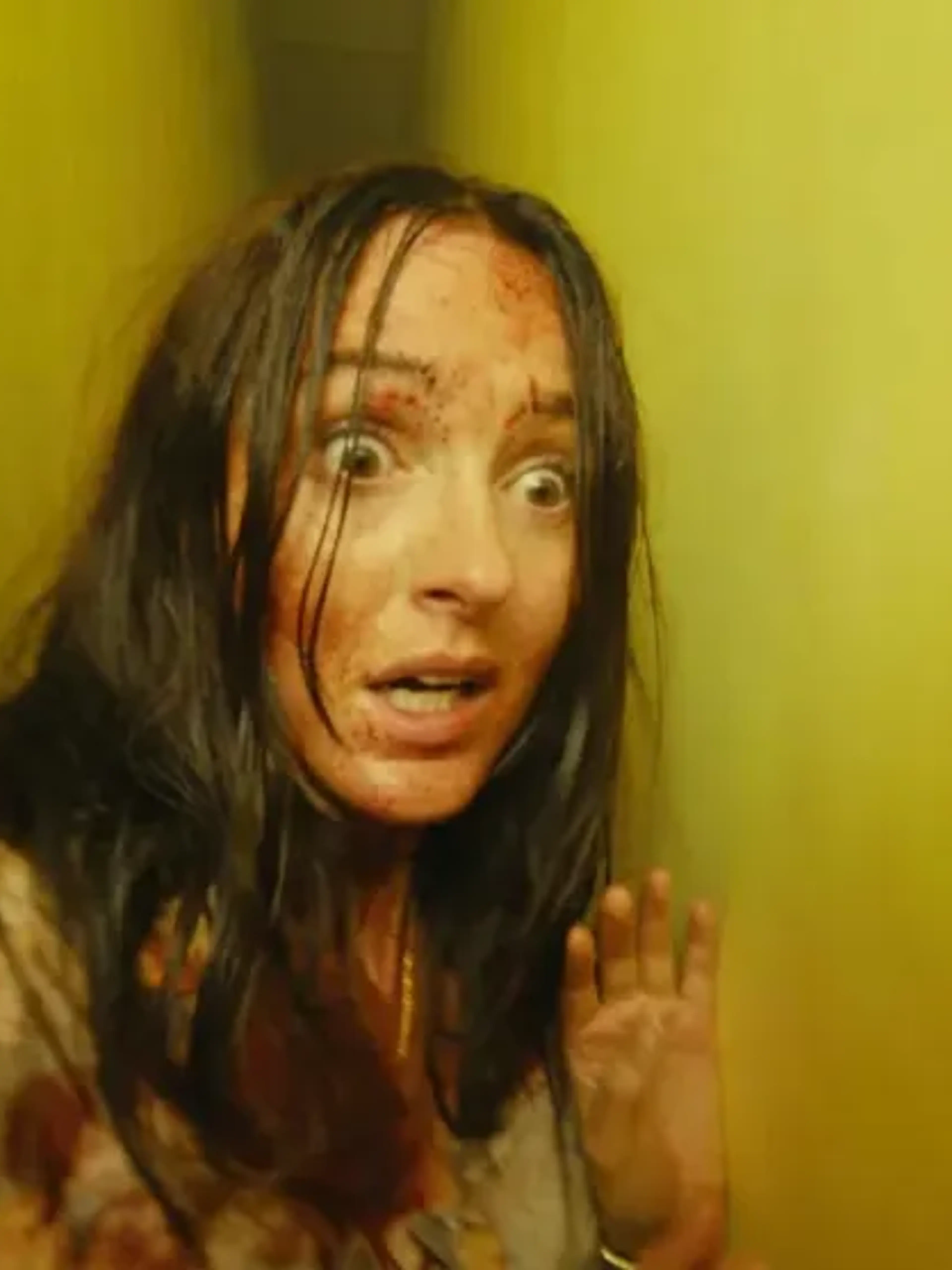 Renate Reinsve’s character stands injured inside a yellow corridor in Backrooms