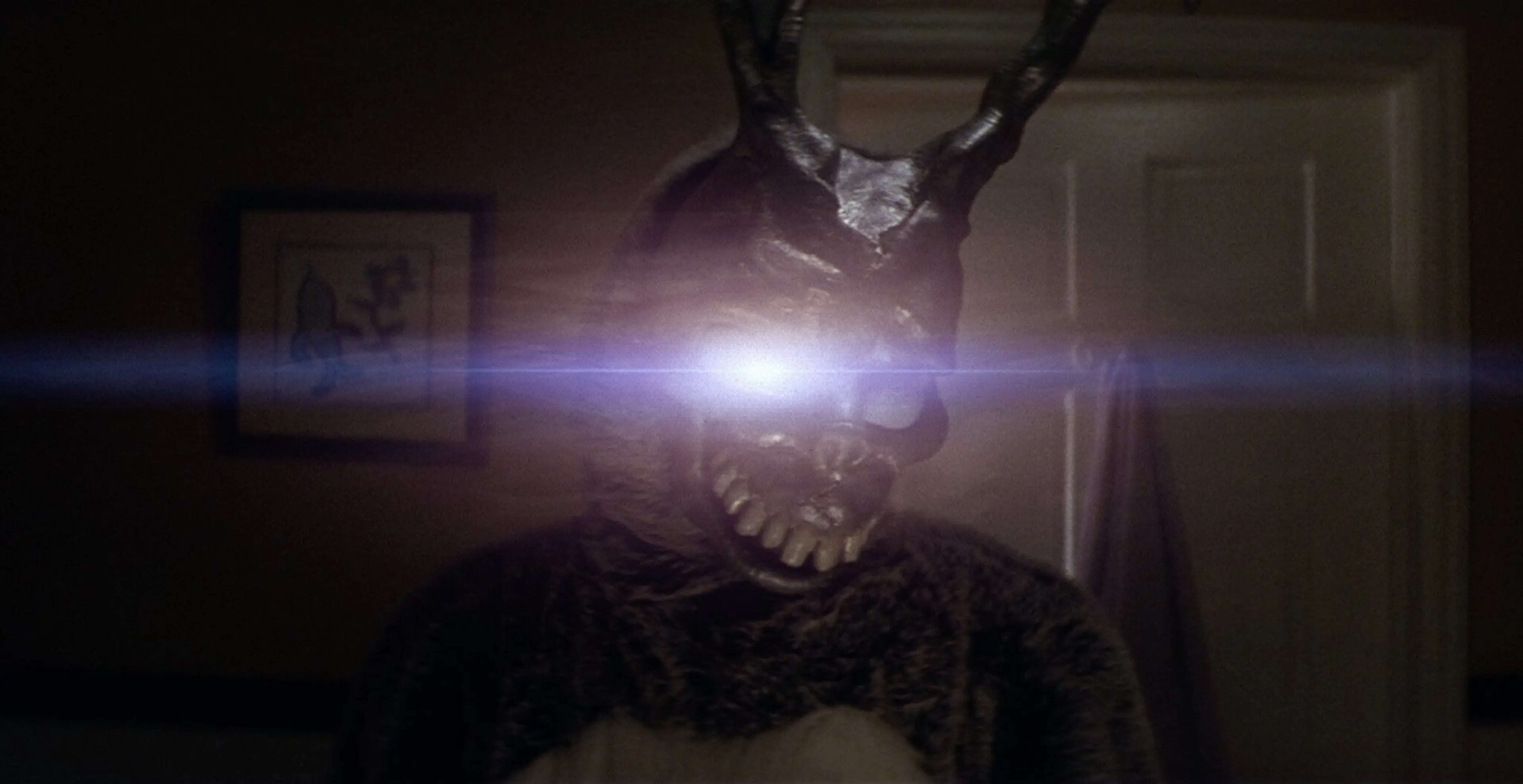 Frank’s silver rabbit mask and a flashlight in a dark scene from Donnie Darko.