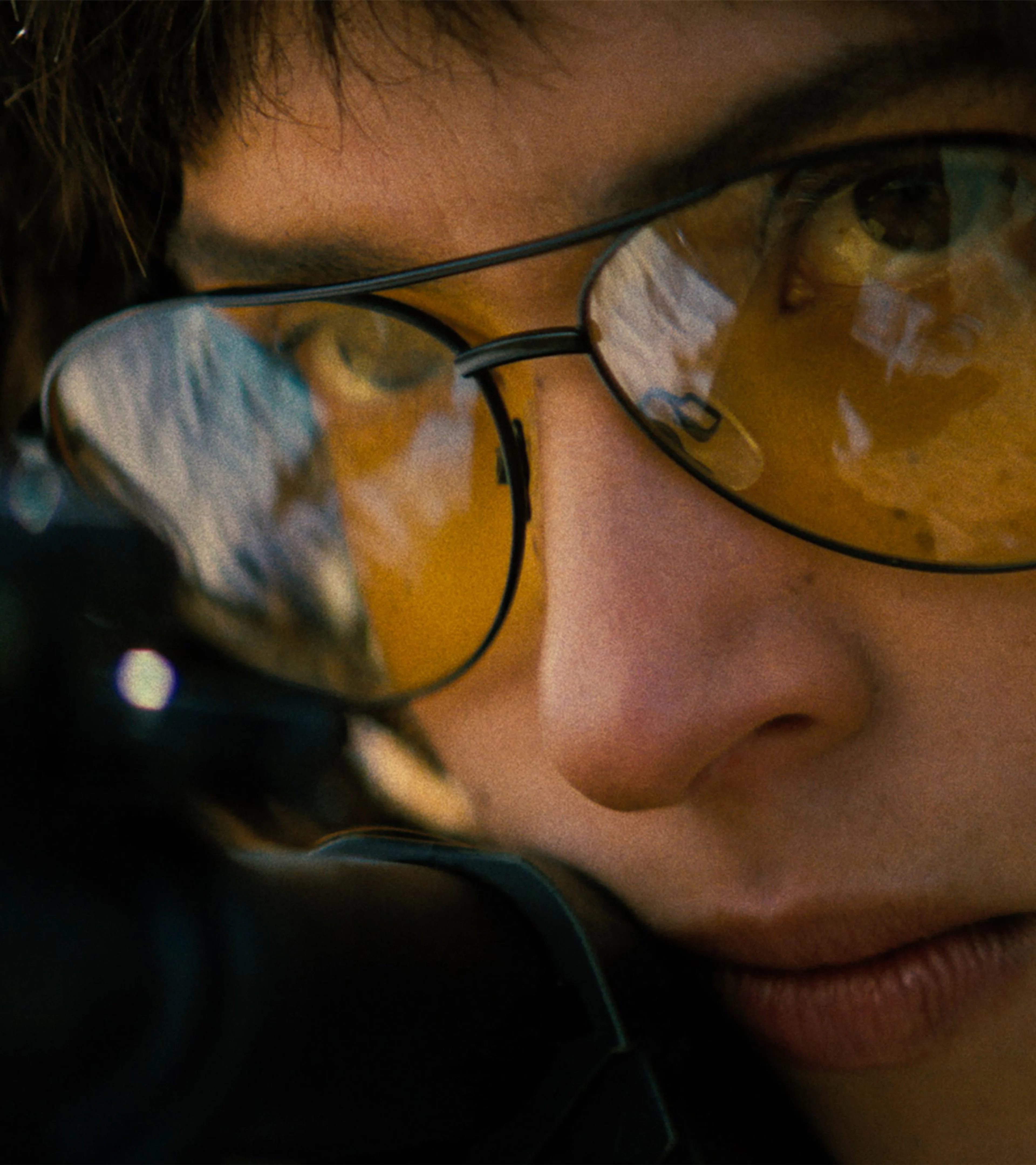 Adria Arjona as Celeste wears amber shooting glasses in a close-up from Onslaught.