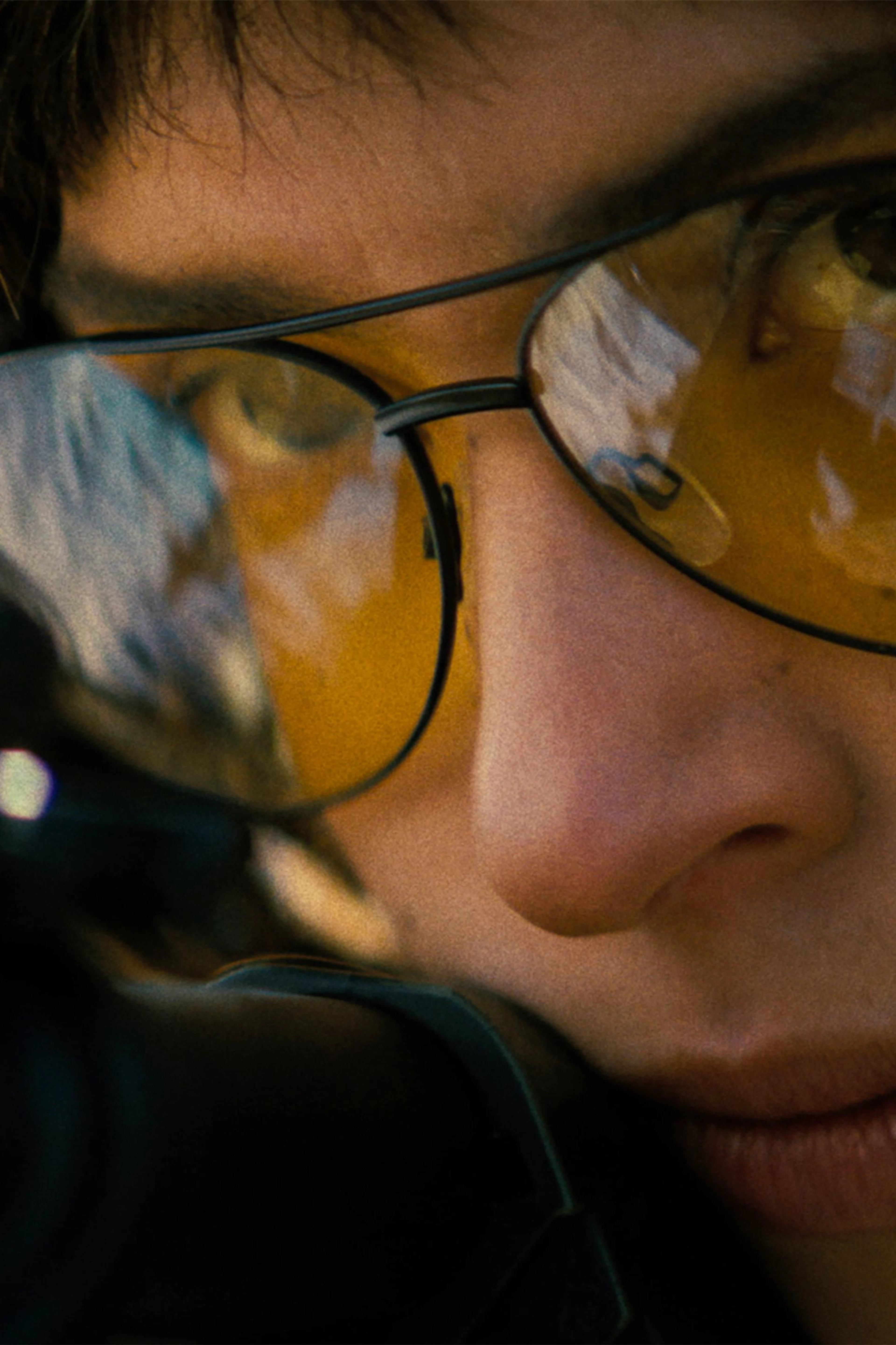Adria Arjona as Celeste wears amber shooting glasses in a close-up from Onslaught.