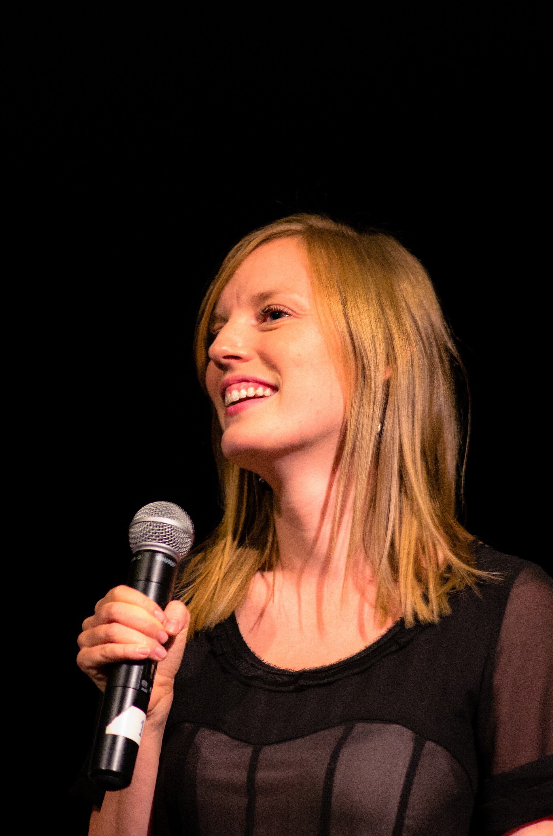 Sarah Polley speaking into a microphone at the 2012 Toronto International Film Festival.