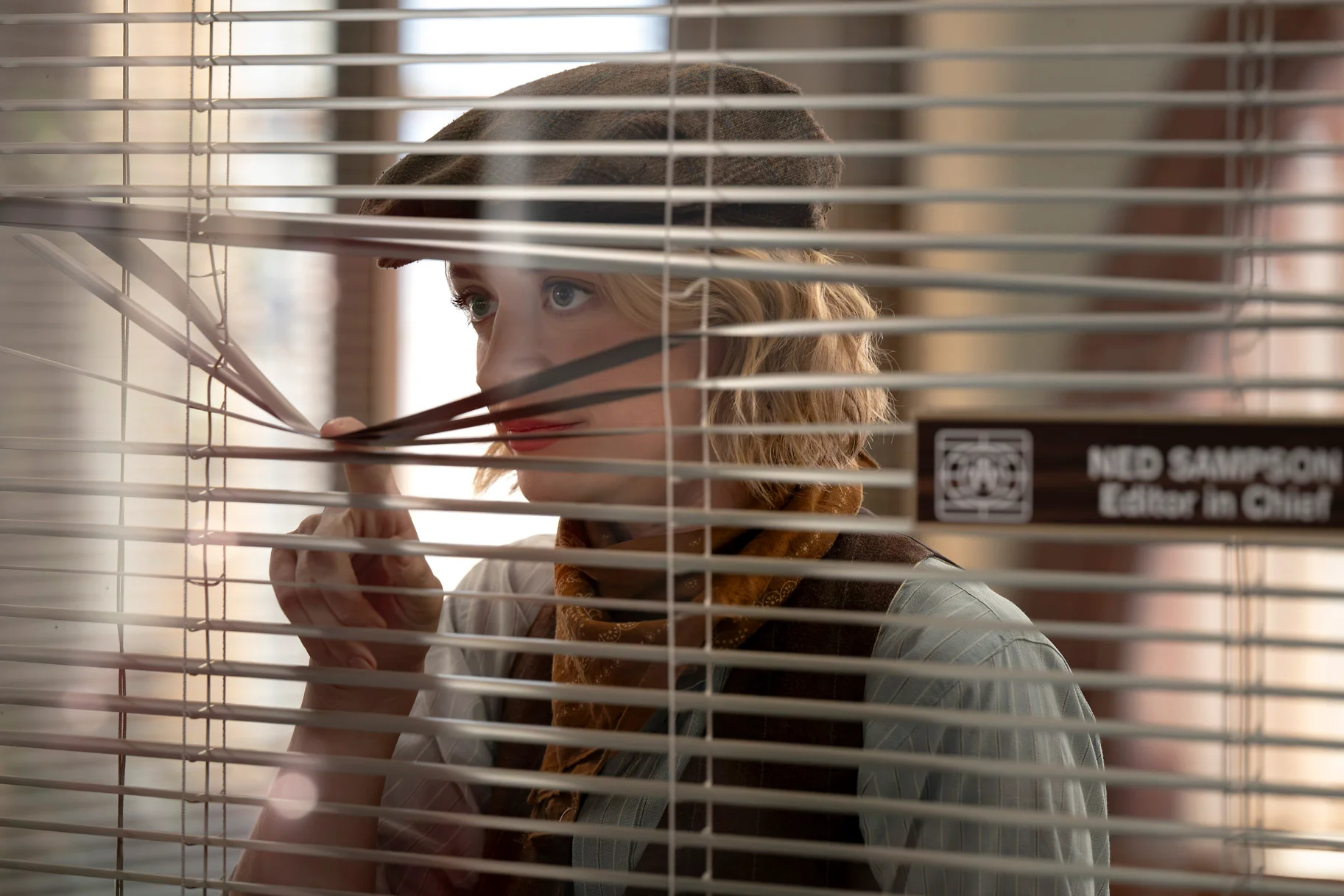 Chelsea Frei as Mare Pritti looks through window blinds in The Paper season two.