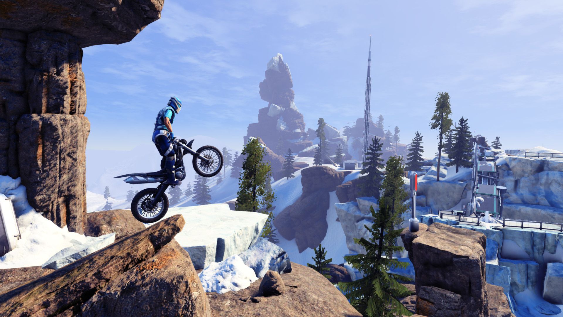 A motorbike balances on the edge of a snow-covered rock.