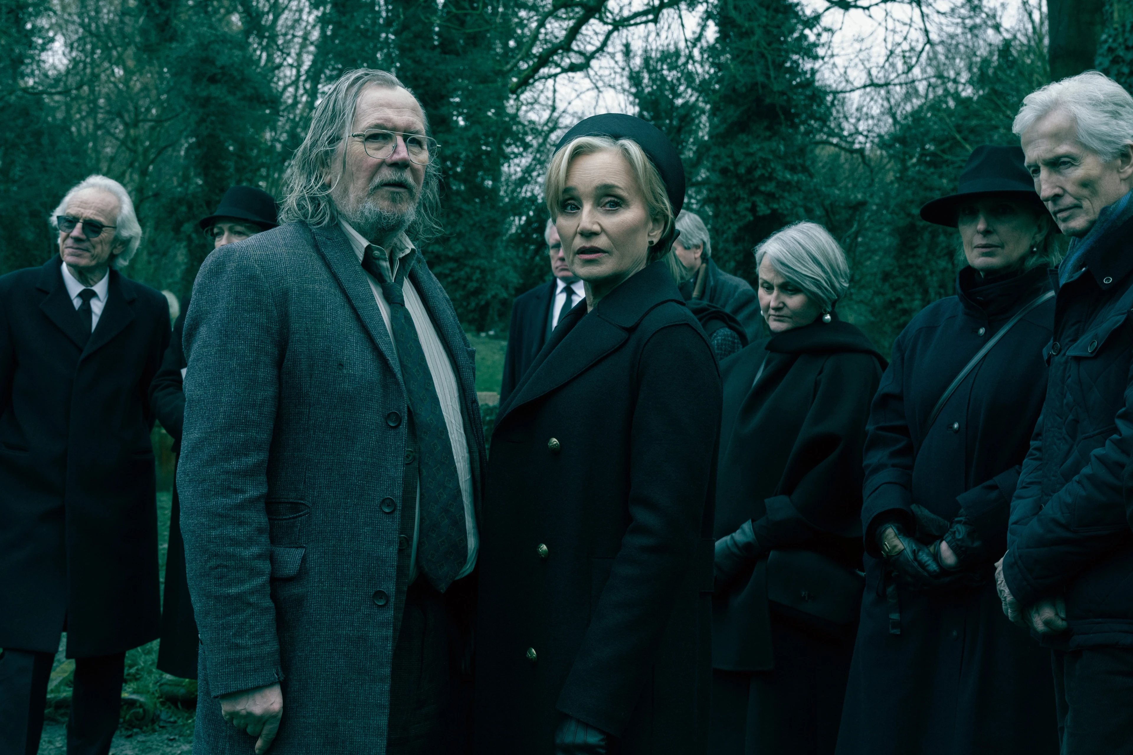 Gary Oldman as Jackson Lamb and Kristin Scott Thomas as Diana Taverner stand at a funeral in Slow Horses Season 6.