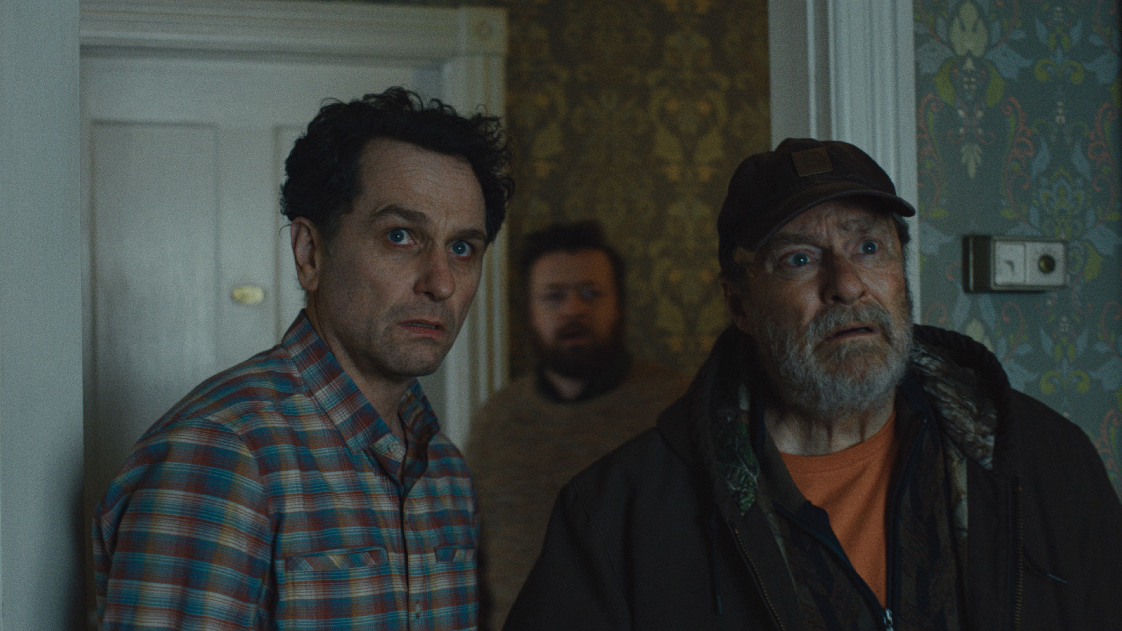 Matthew Rhys and Stephen Root stand in the doorway of the inn in Widow’s Bay.