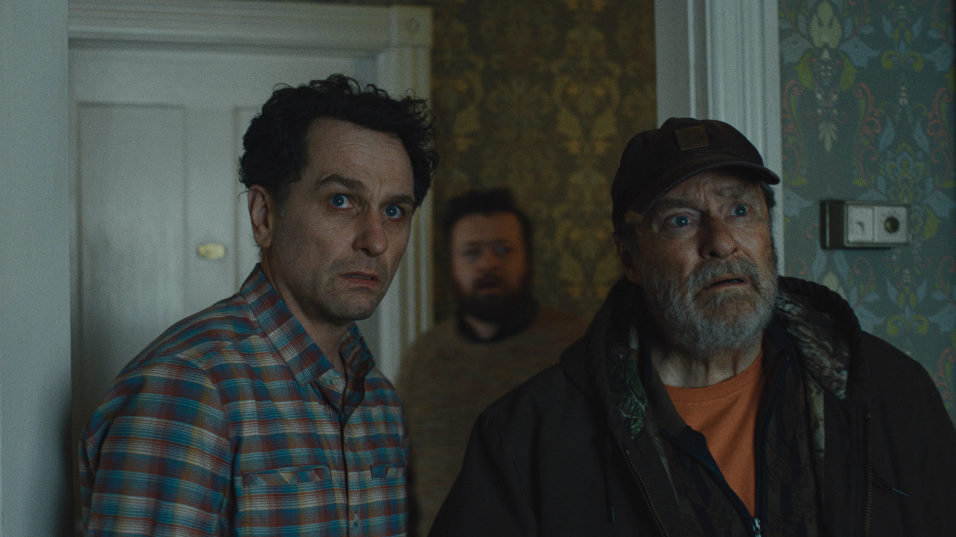 Matthew Rhys and Stephen Root stand in the doorway of the inn in Widow’s Bay.