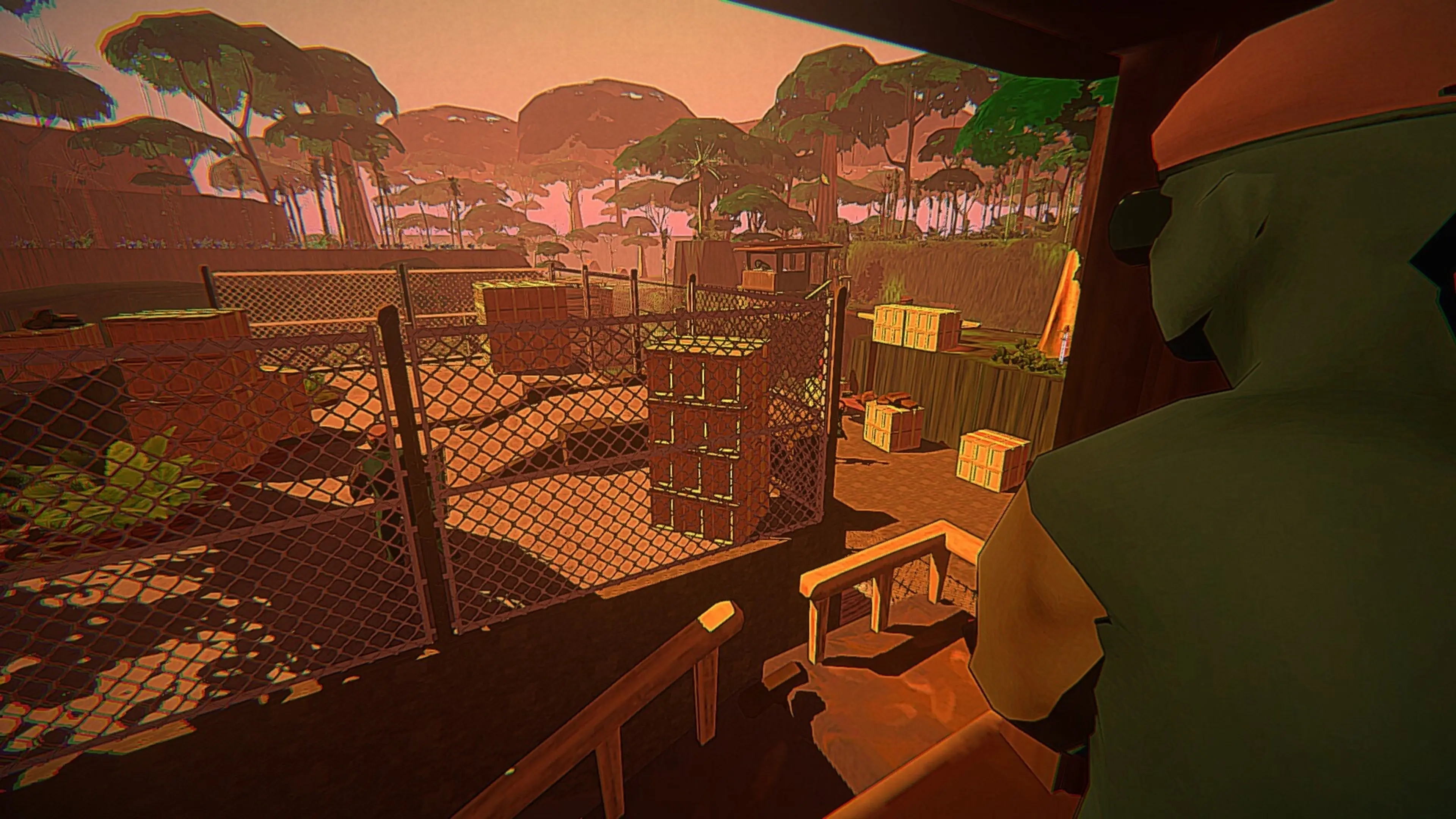 Alphonse Harding looks over a fenced tropical military compound at sunset while holding a riot shield.