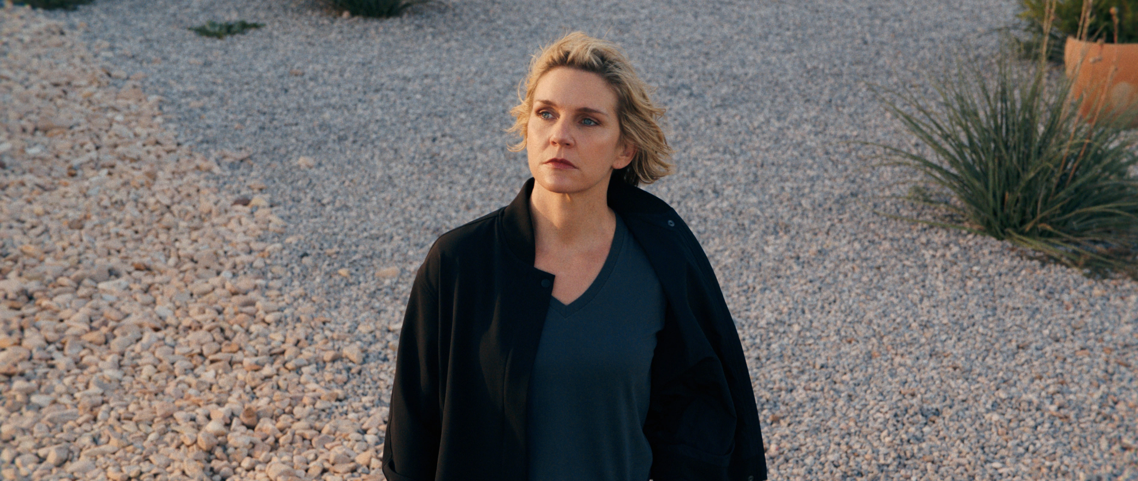Rhea Seehorn as Carol Sturka stands outdoors in Pluribus.