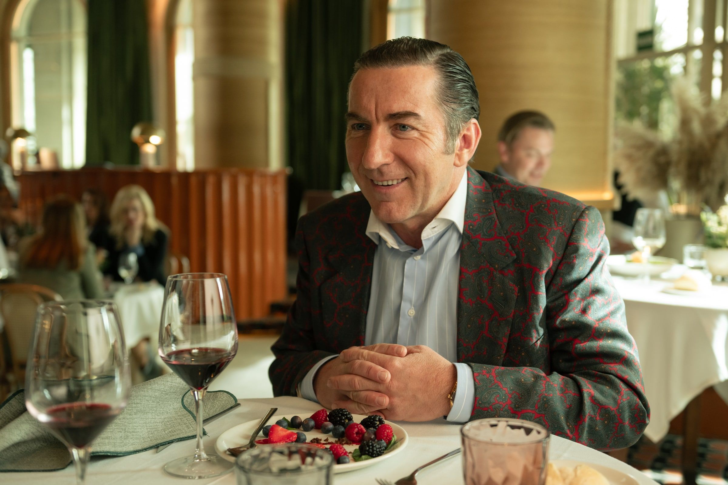 Don Leandro smiles while sitting at a restaurant table.