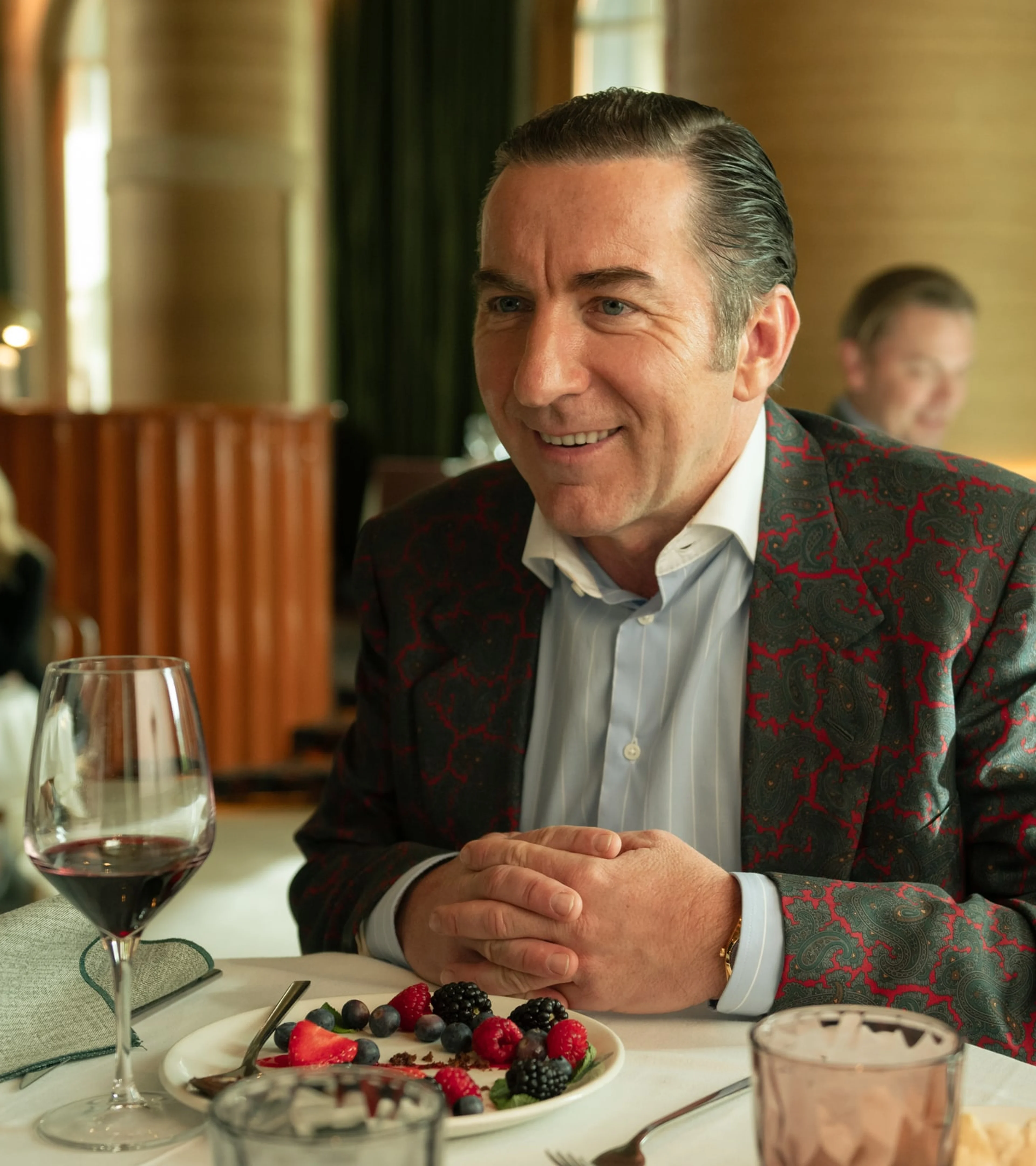 Don Leandro smiles while sitting at a restaurant table.